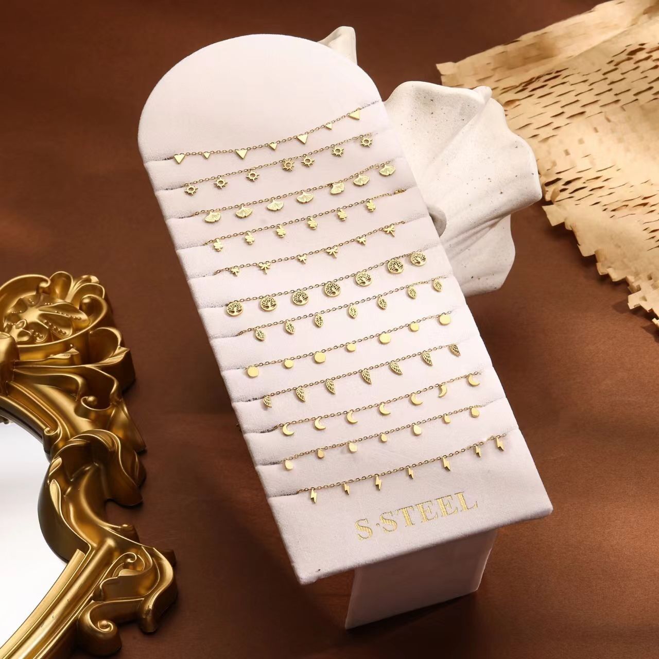 Set di 12 cavigliere in oro fino con vari ciondoli (fiori, ali, foglie…)