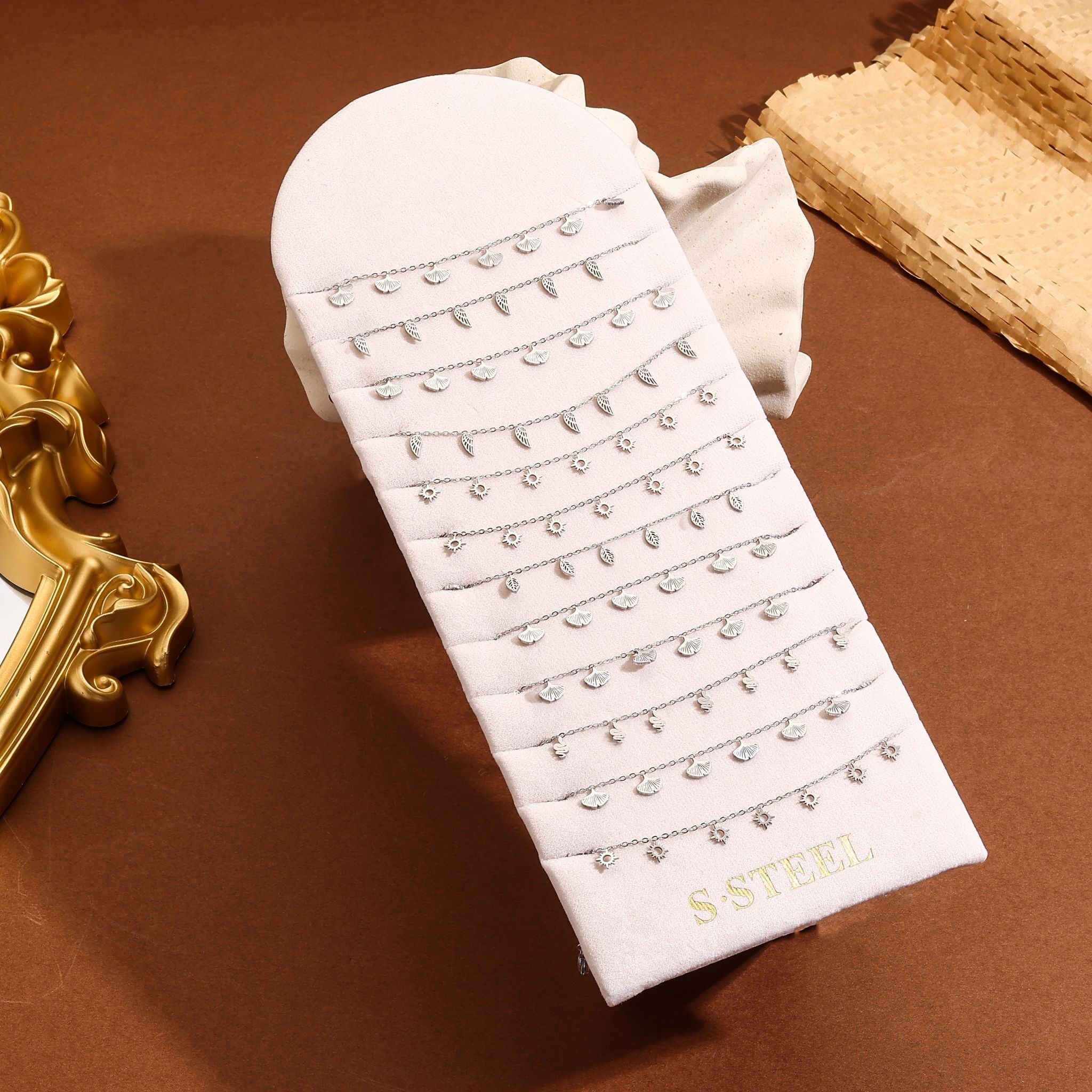 Set di 12 cavigliere a maglie sottili placcate in argento con vari ciondoli (fiori, ali, foglie…)