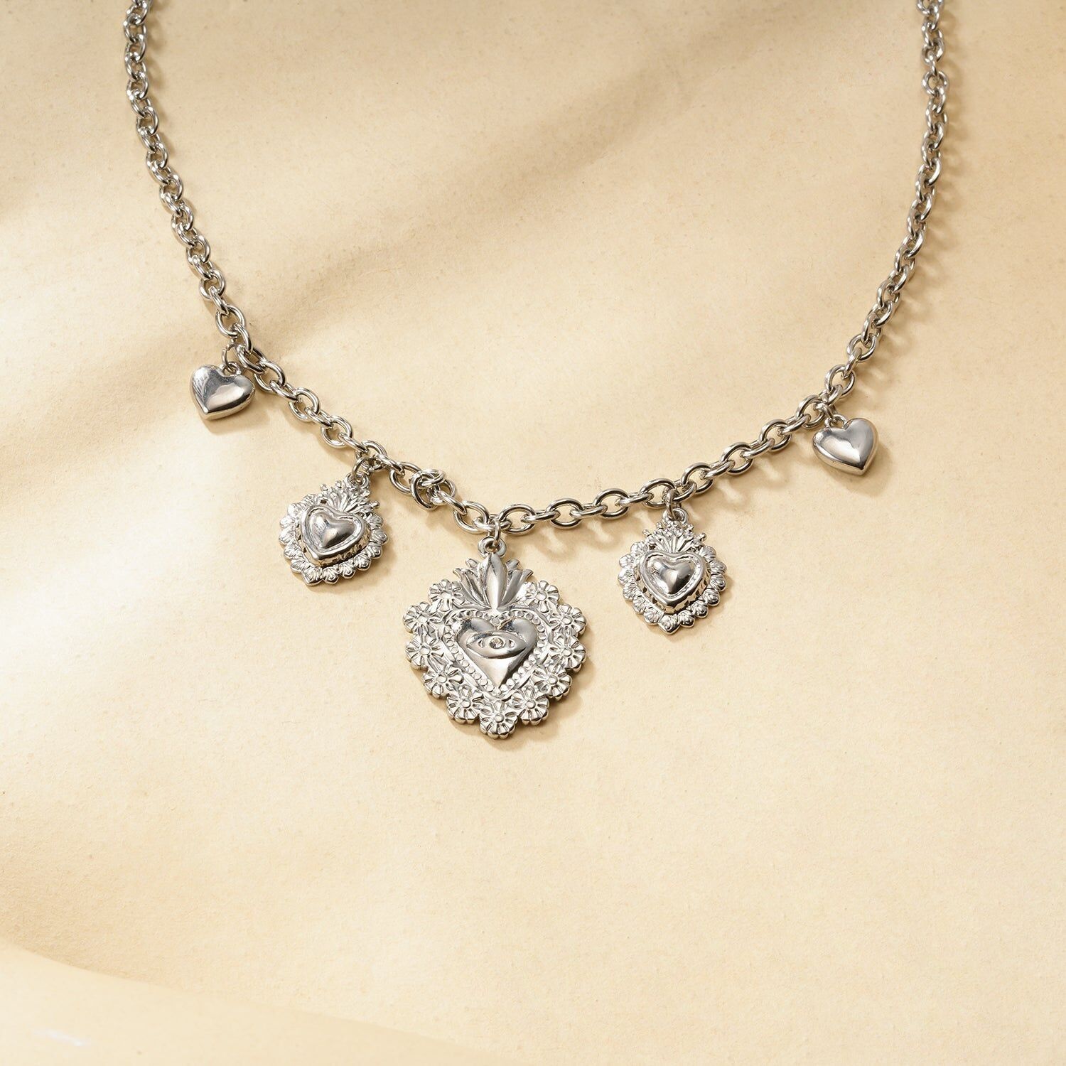 Collana a catena in argento con ciondoli a forma di cuore bombato ed ex voto cesellati