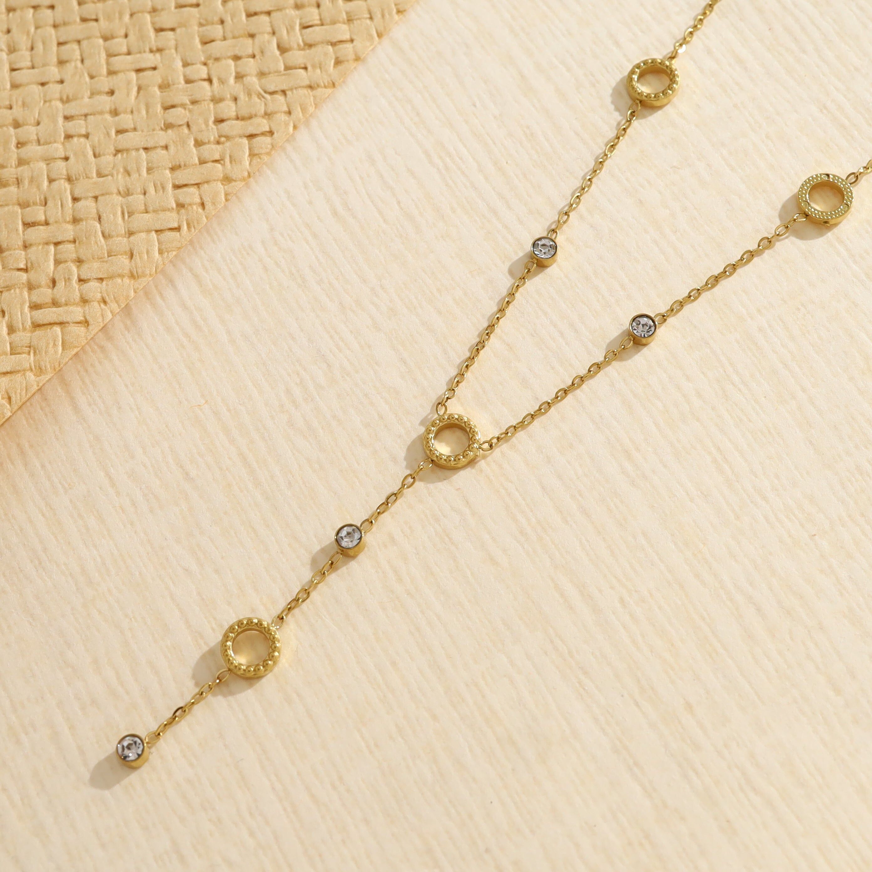 Collana a catena a forma di Y color oro decorata con cerchi testurizzati e strass