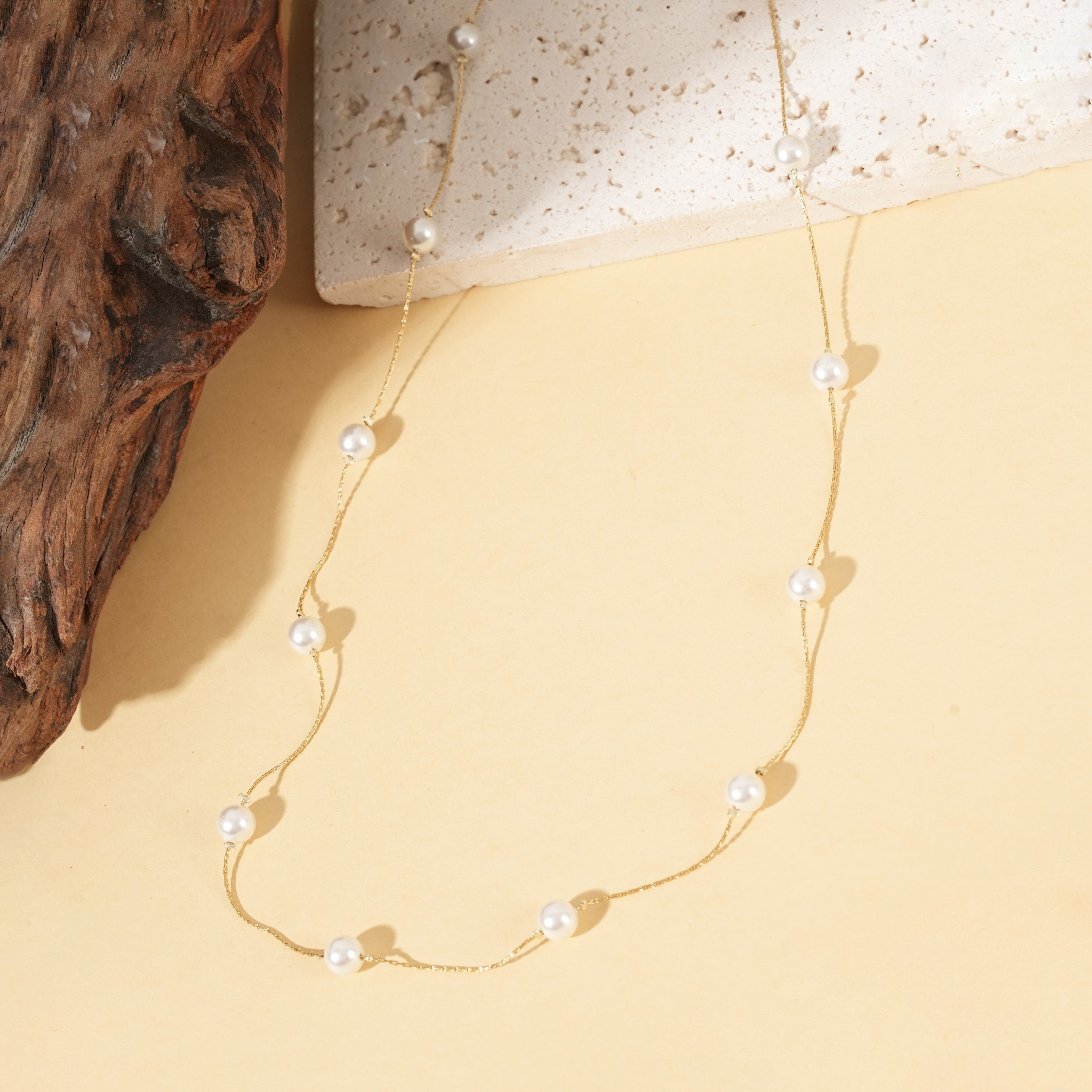 Collana lunga con una sottile catena d'oro ornata di perle