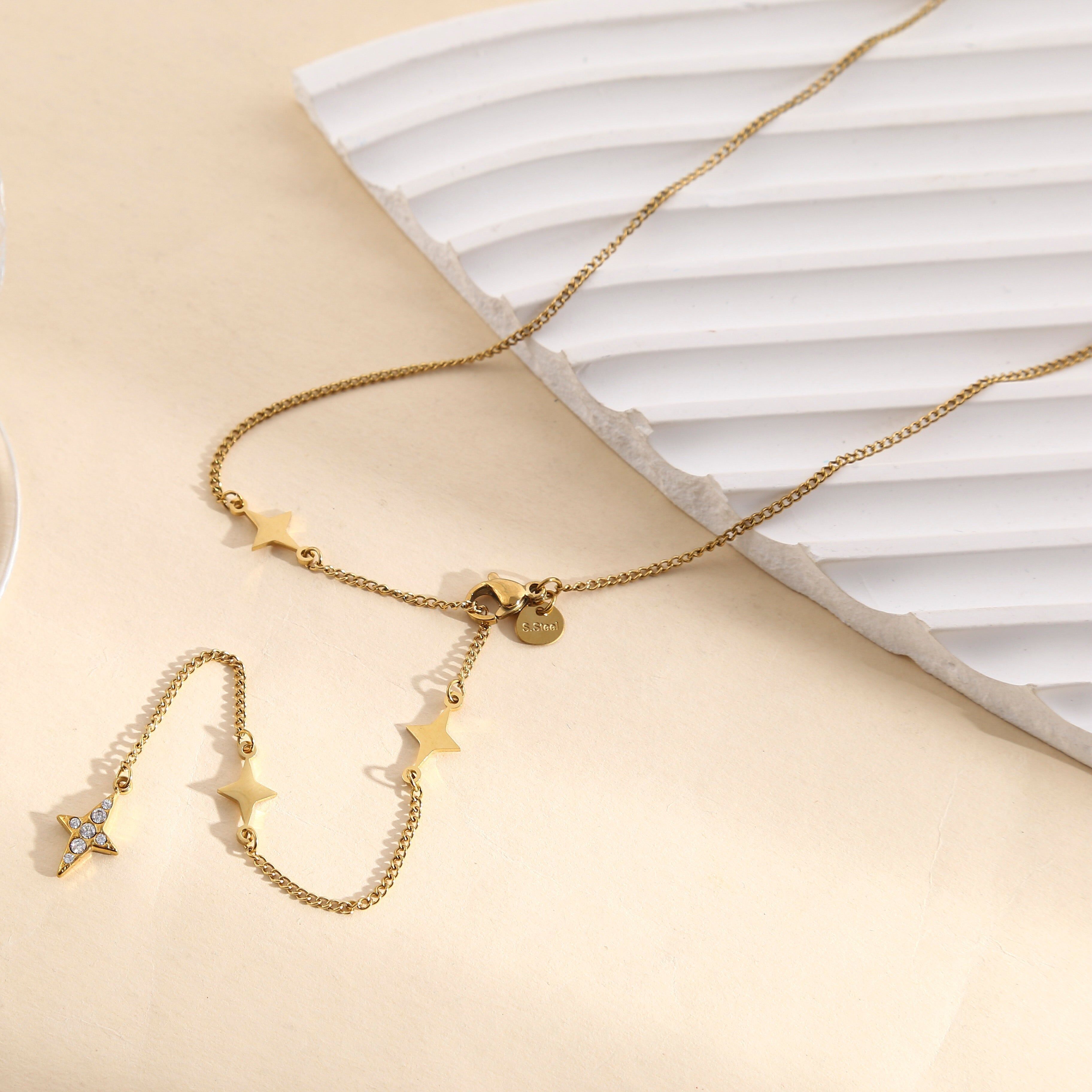 Collana color oro con catena sottile incastonata con chiusura a stella a quattro punte e stella di strass