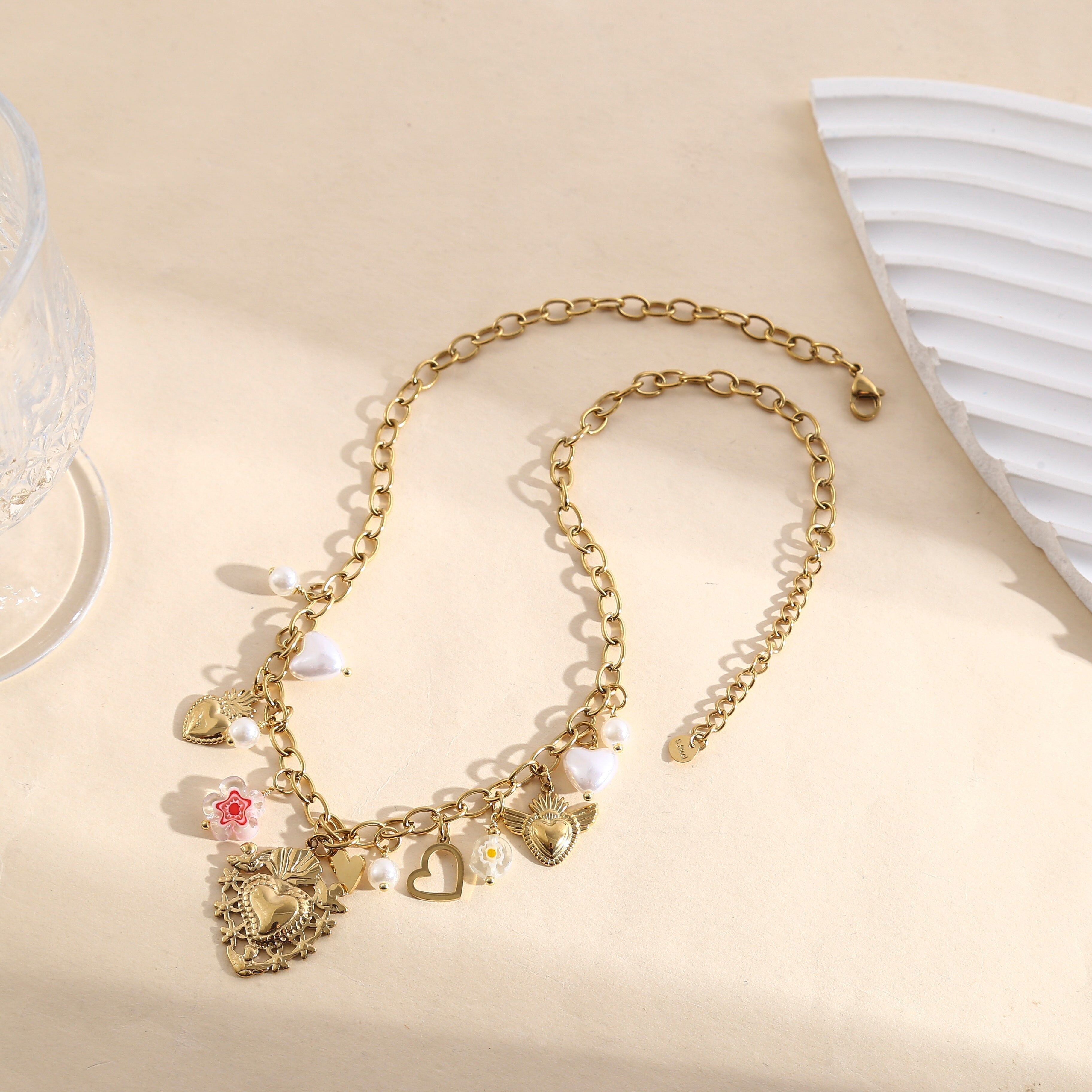 Collana a catena in oro con nappe a forma di cuore ex voto, perline irregolari e ciondoli floreali smaltati