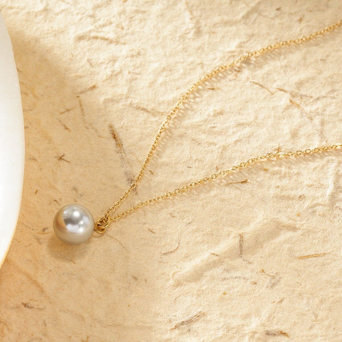 Collana in oro con catena sottile e pendente a forma di sfera di perla grigia