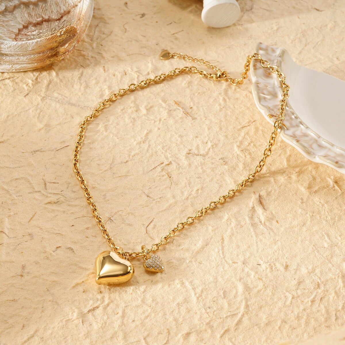 Collana a catena in oro con pendenti a forma di cuore lisci e bombati e strass