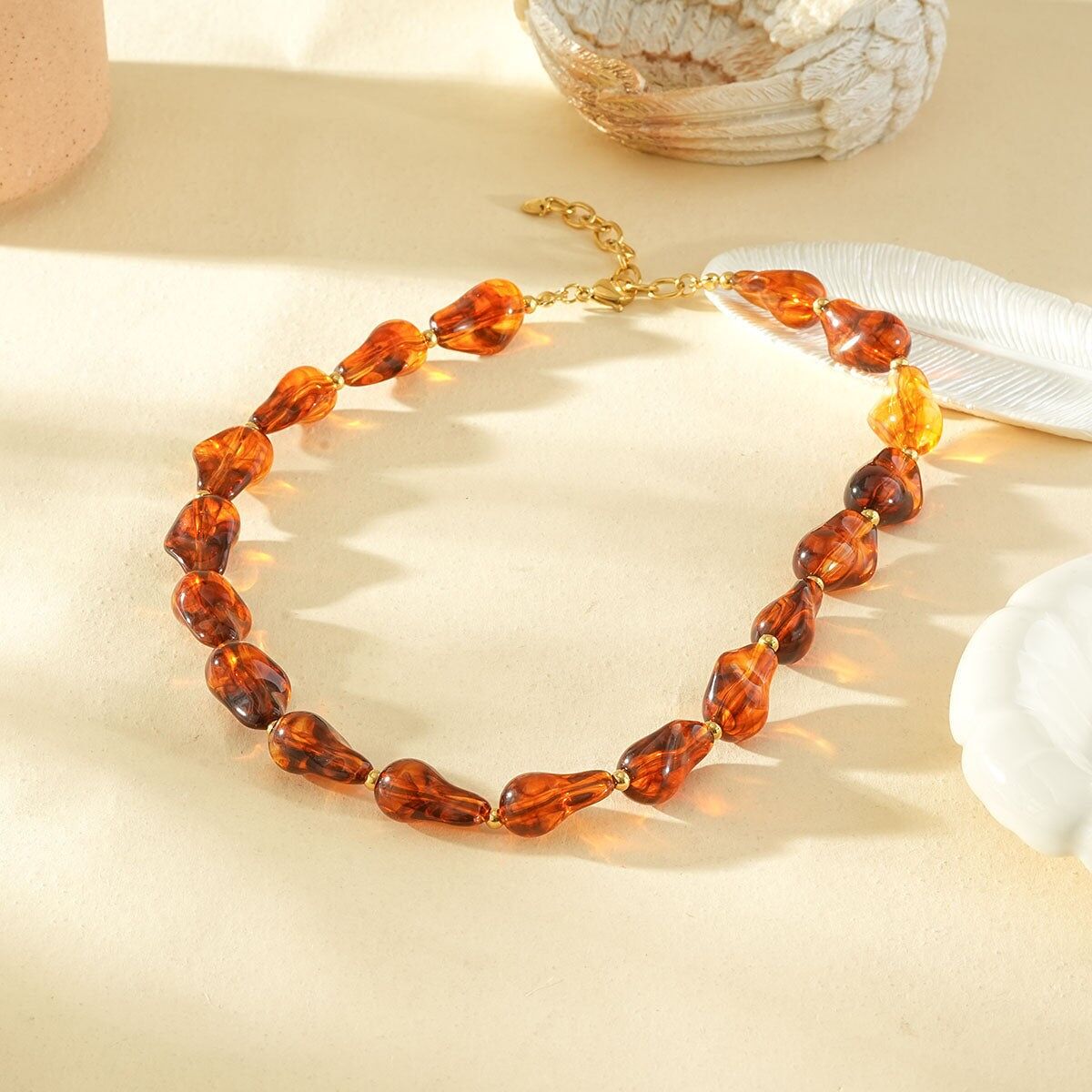 Collana in resina con forme irregolari, color ambra marrone, separatori in oro