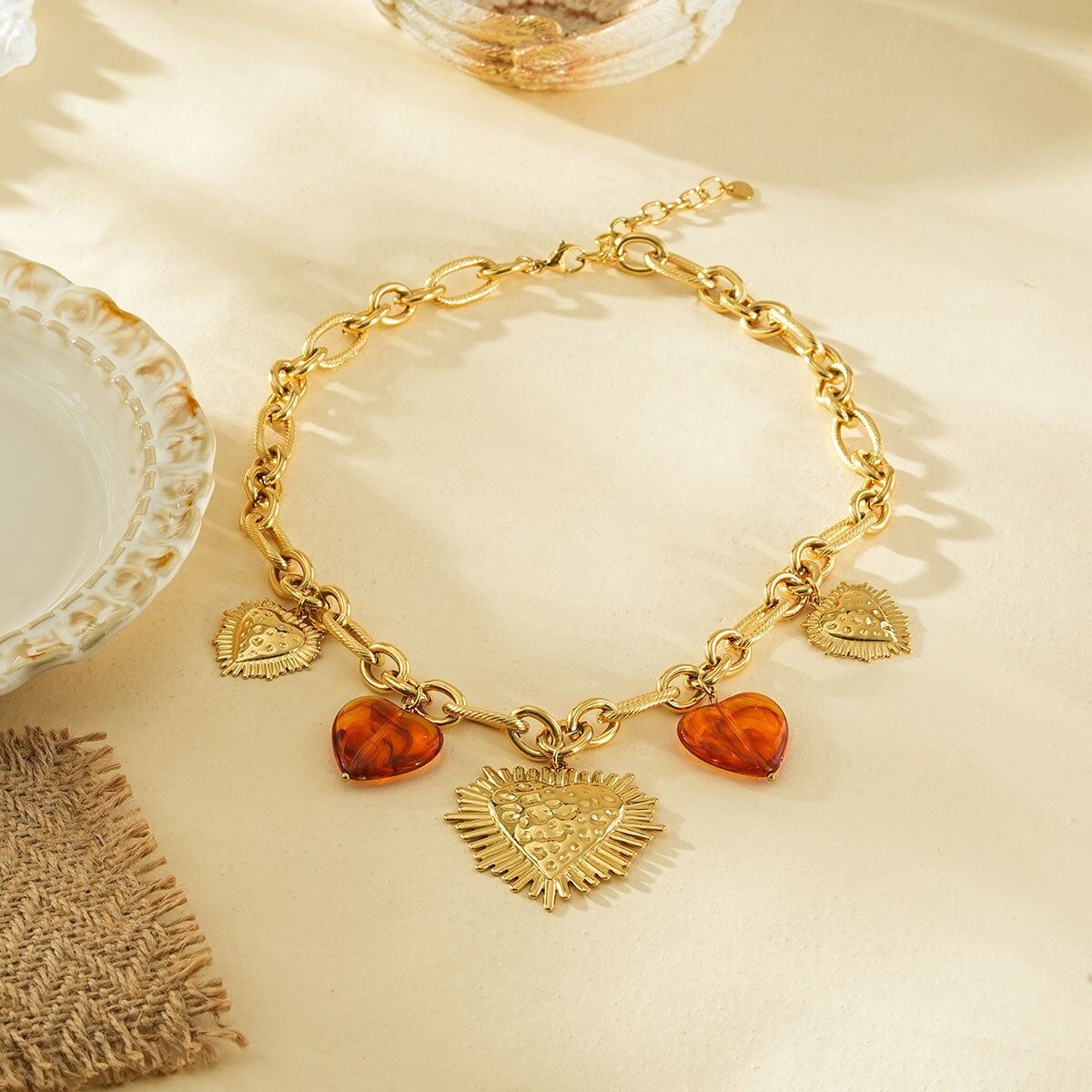 Collana a catena in oro con cuori ex voto martellati larghi e resina marrone