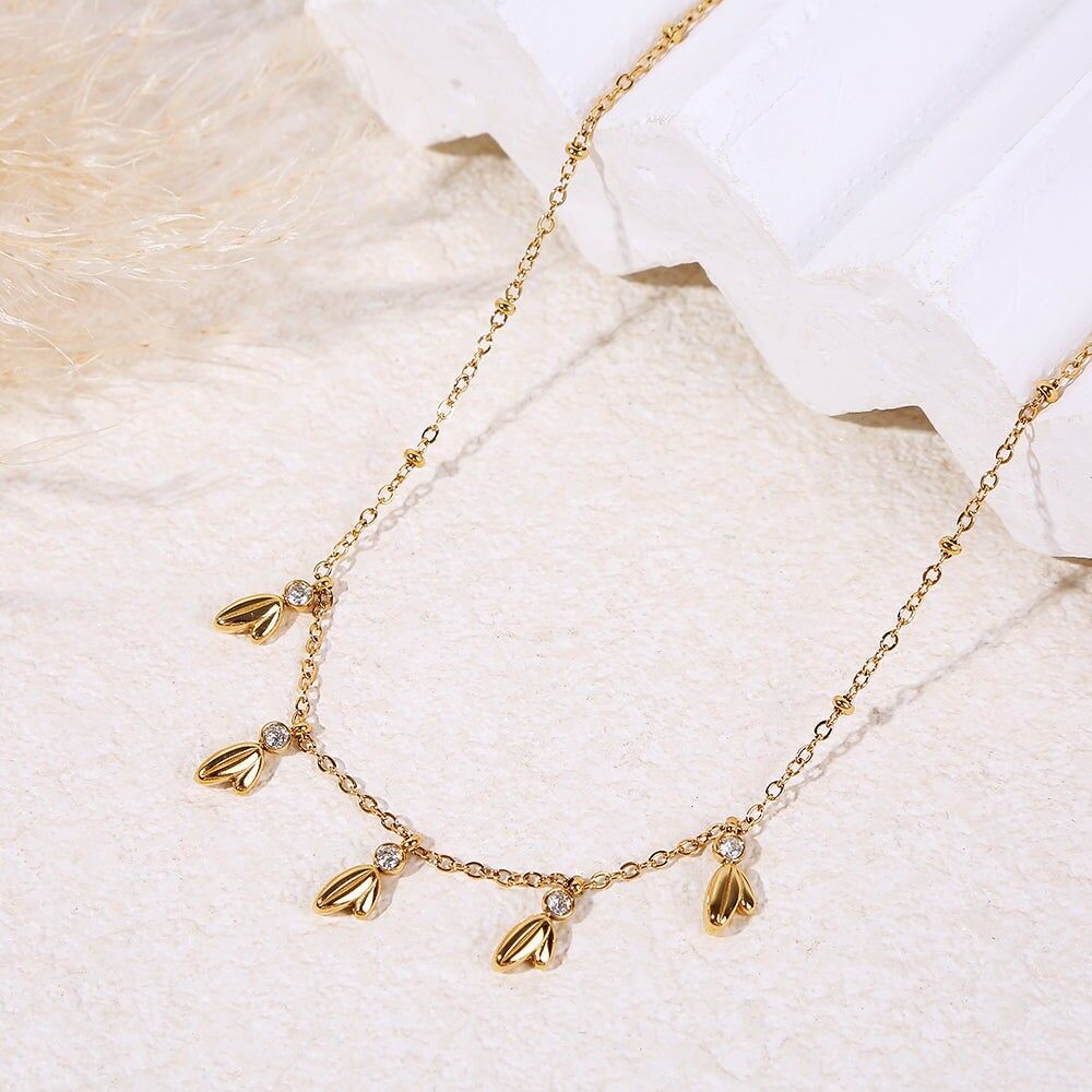 Collana color oro con catena sottile ornata da un ciondolo a forma di foglia e strass
