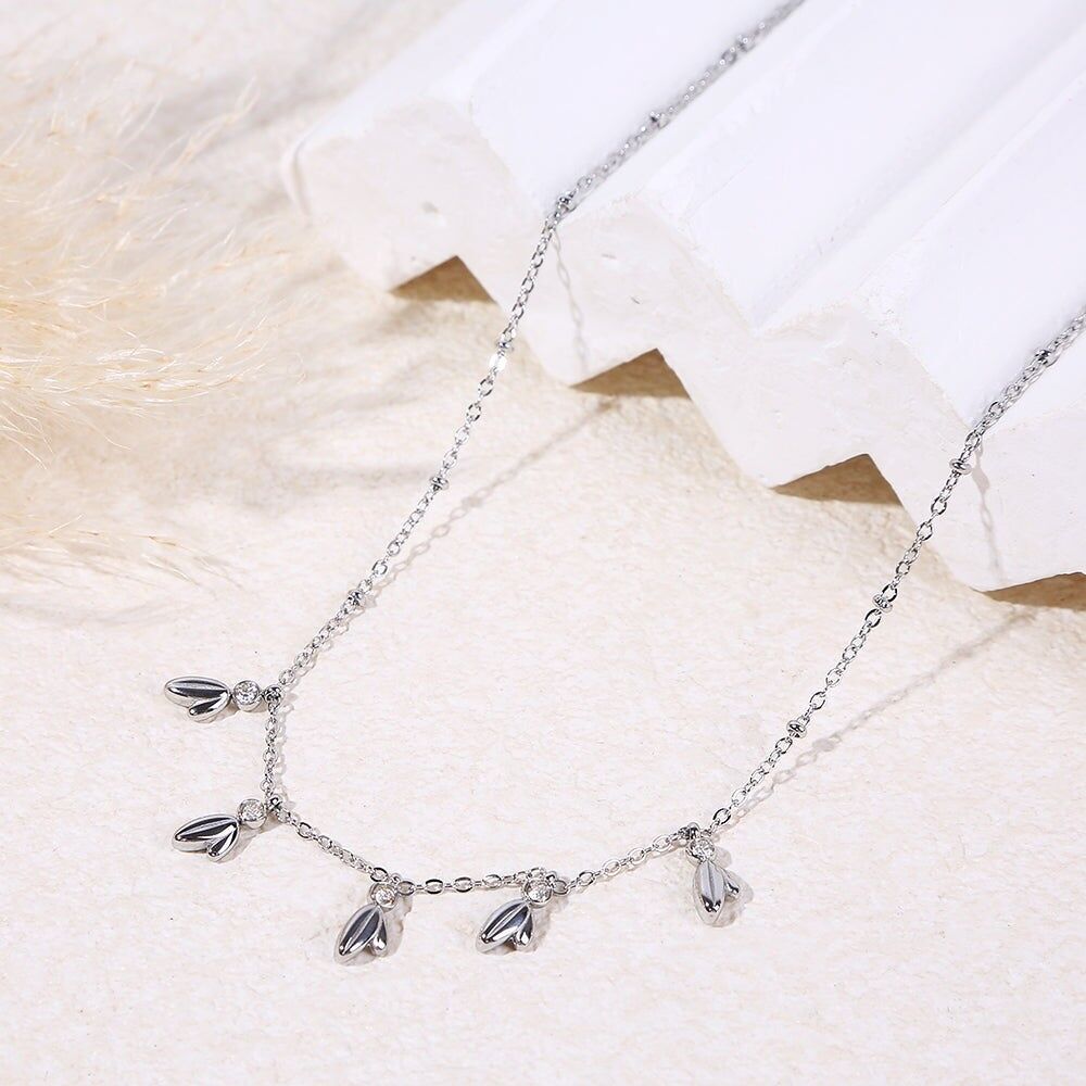 Collana in argento con catena sottile ornata da un ciondolo a forma di foglia e strass