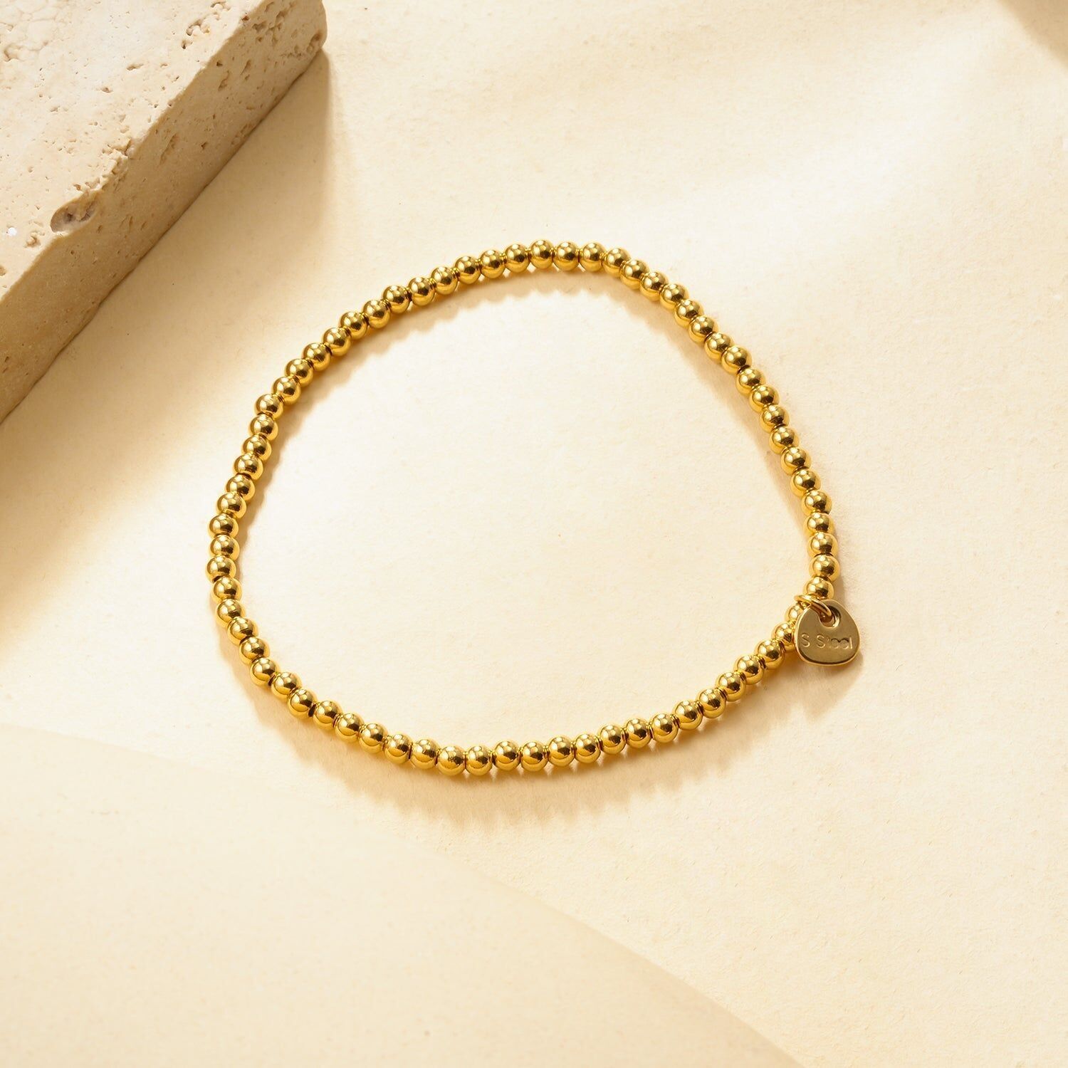 Bracciale elastico in oro con perle lisce effetto specchio