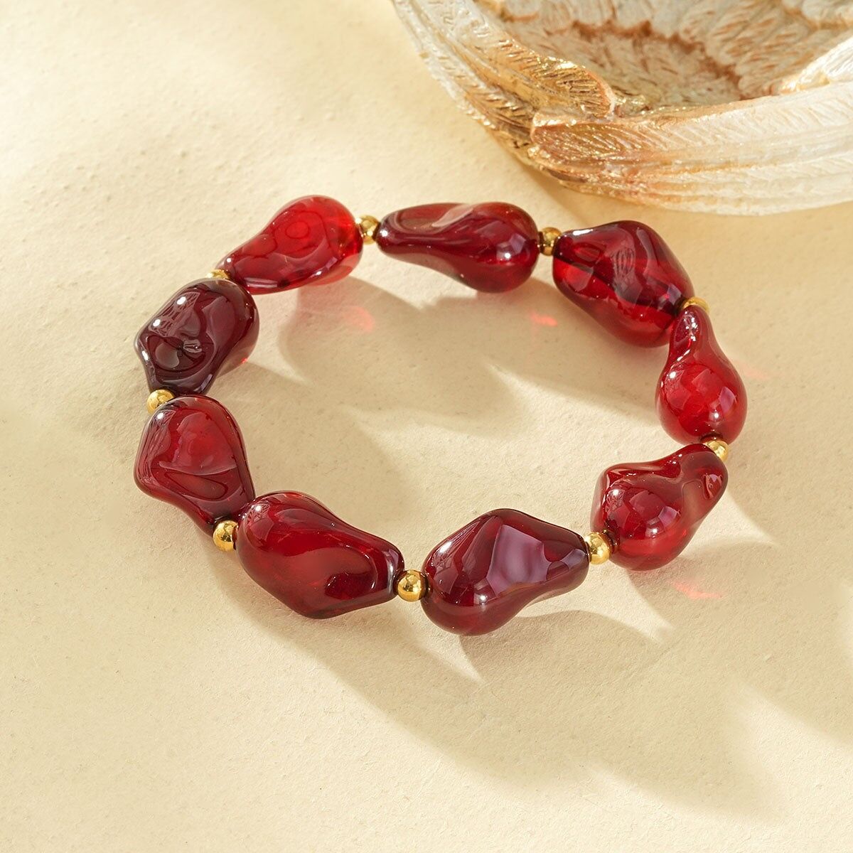 Bracciale elastico in resina con forme irregolari, rosso ambra, separatori in oro