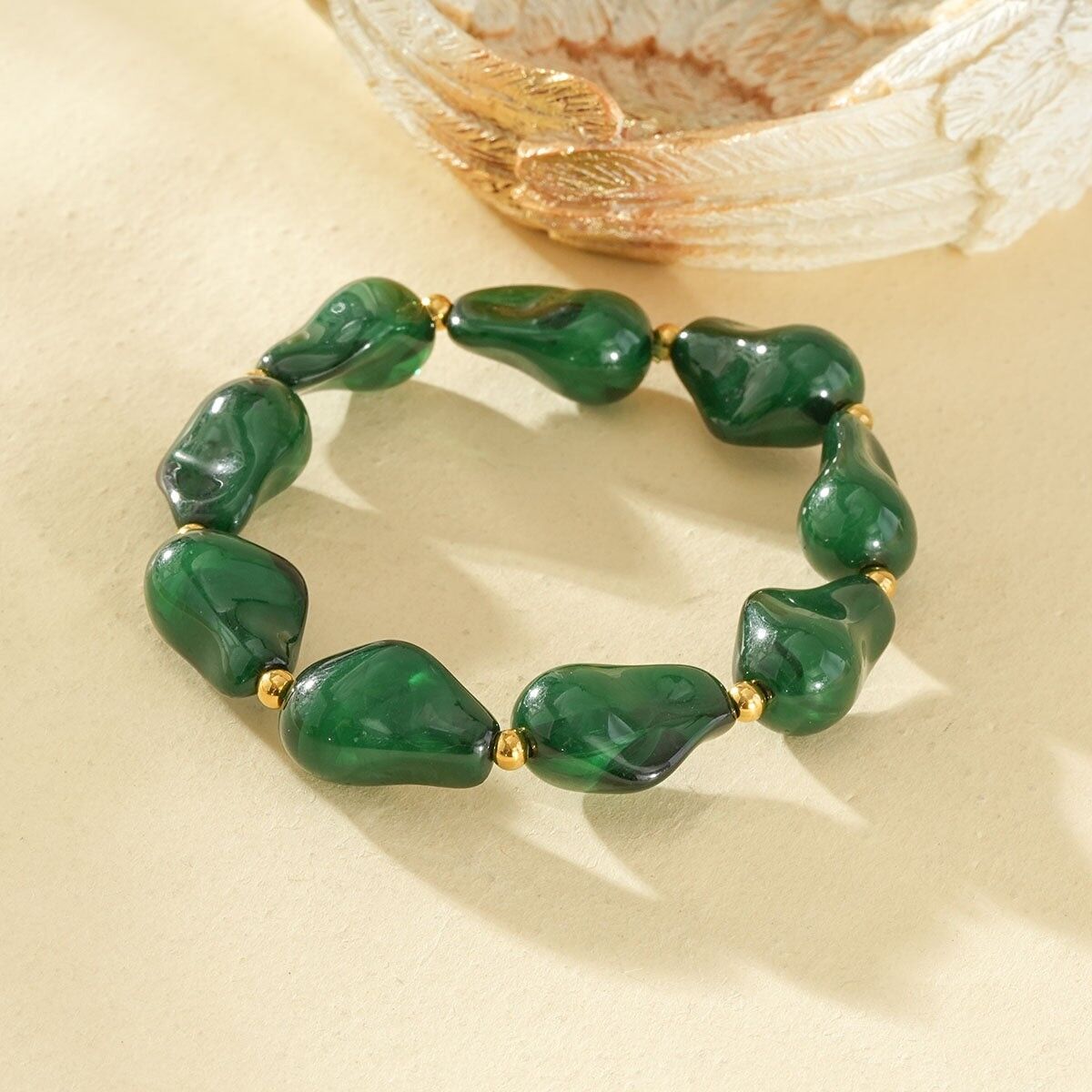 Bracciale elastico in resina con forme irregolari, verde ambra, separatori in oro