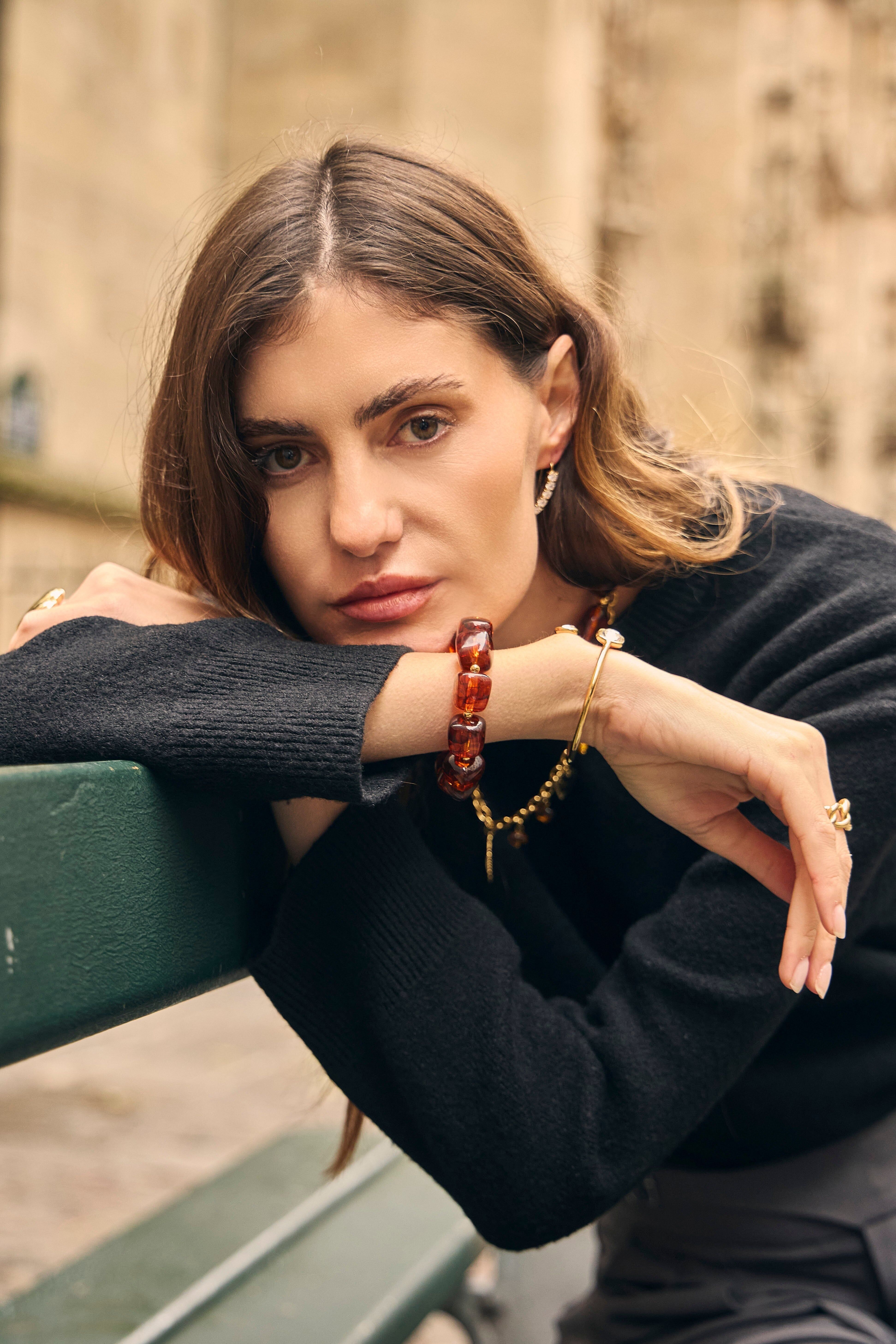 Bracciale elastico in resina dalla forma geometrica color ambra-marrone con perline dorate