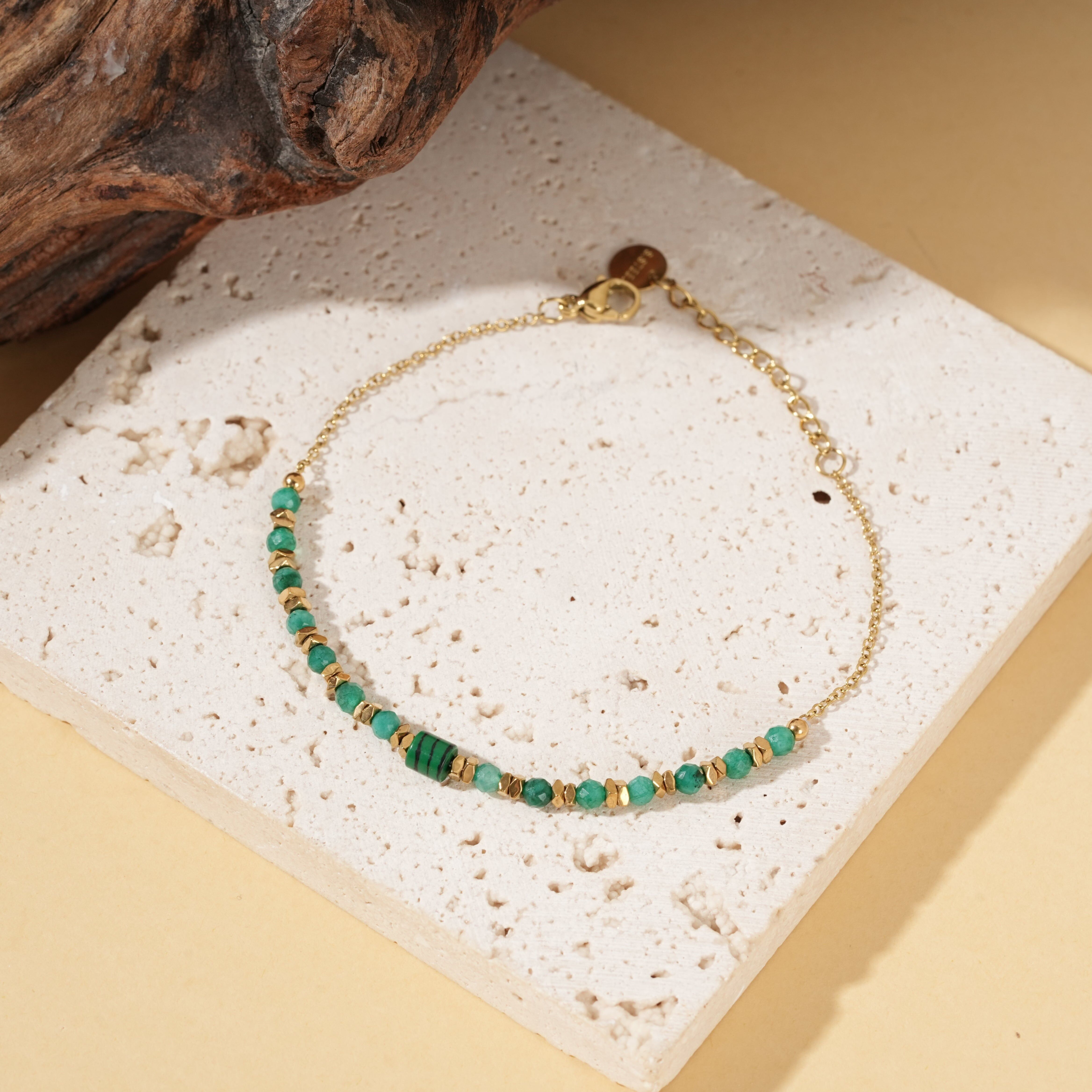Bracciale in oro con catena sottile e pietre di malachite sintetica, pietra centrale cilindrica.
