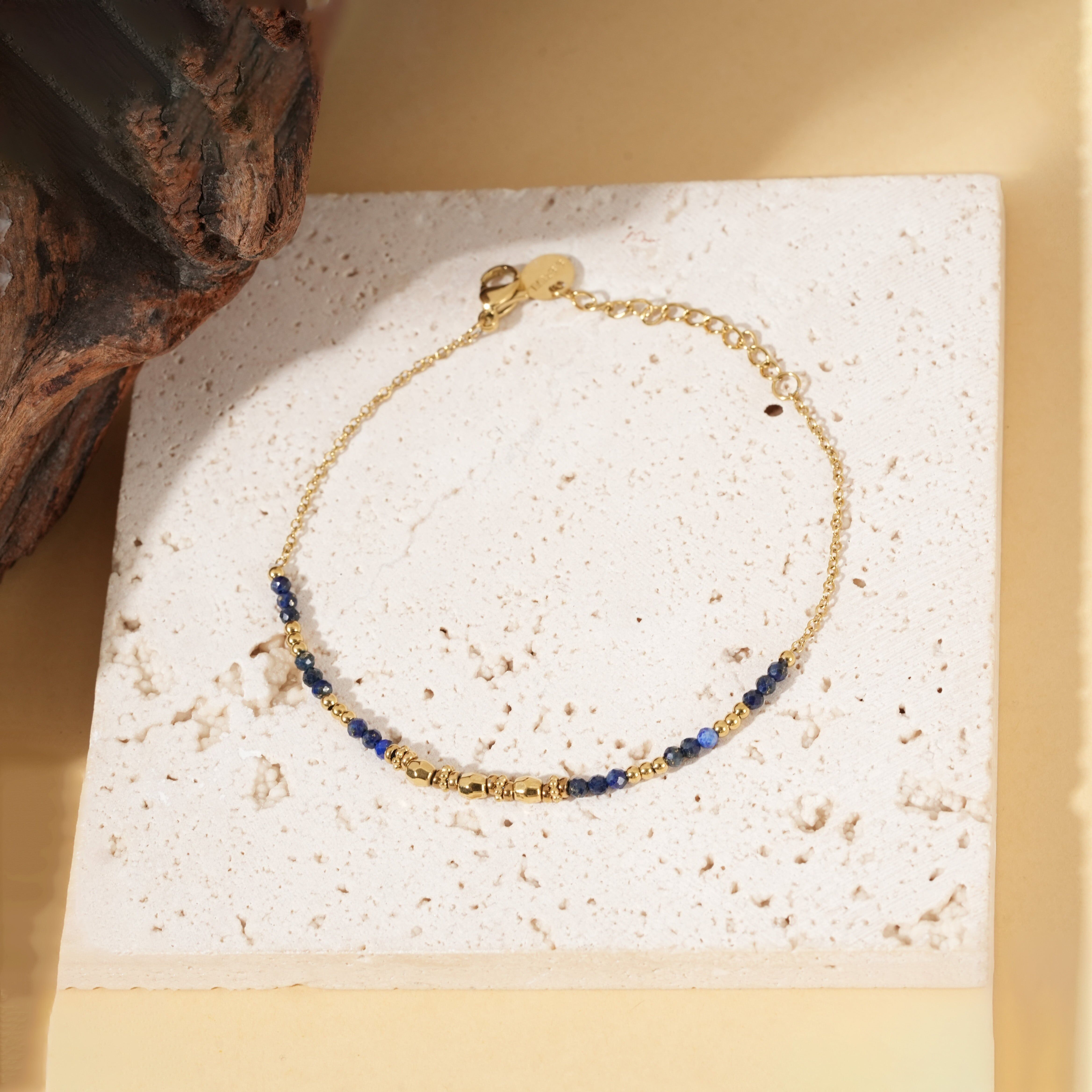 Bracciale in oro con una sottile catena di perle di lapislazzuli e perle dorate