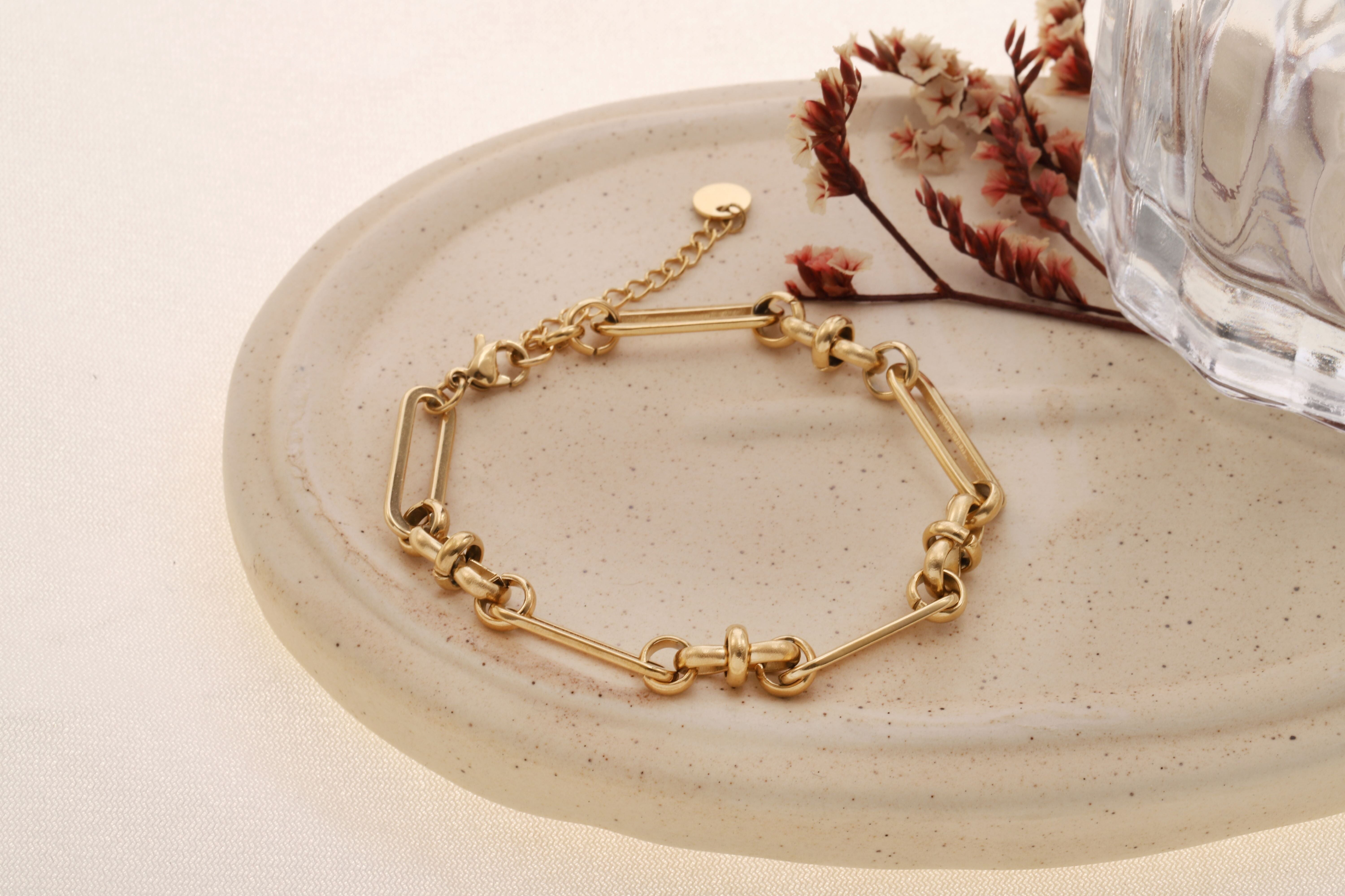 Bracciale color oro con lunghe maglie ovali e anelli rotondi intervallati