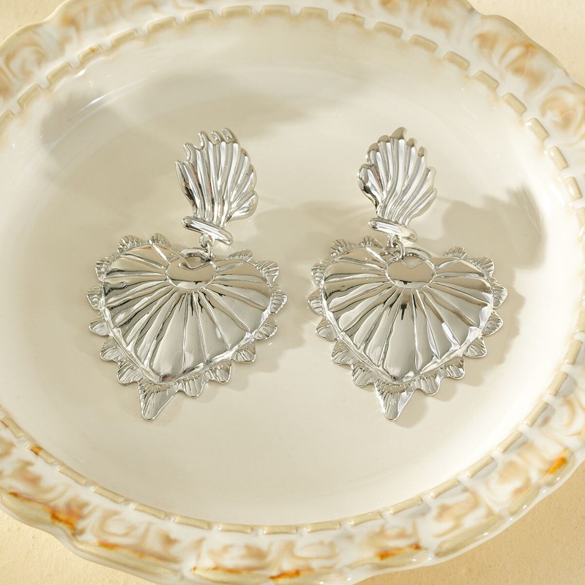 Orecchini pendenti color argento con un grande cuore bombato testurizzato