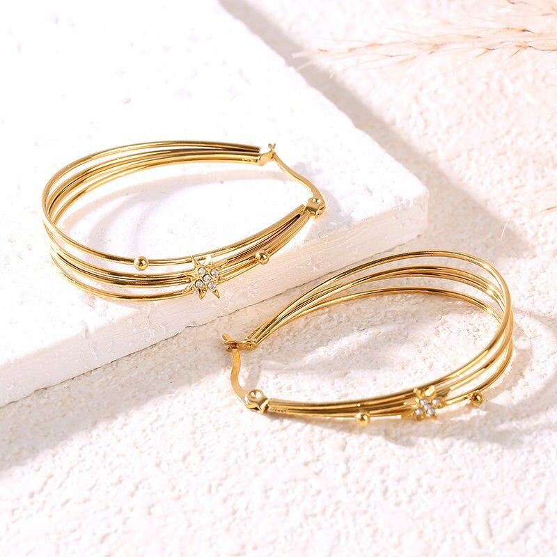 Orecchini placcati in oro con quattro anelli ovali collegati e decorati con stelle di strass