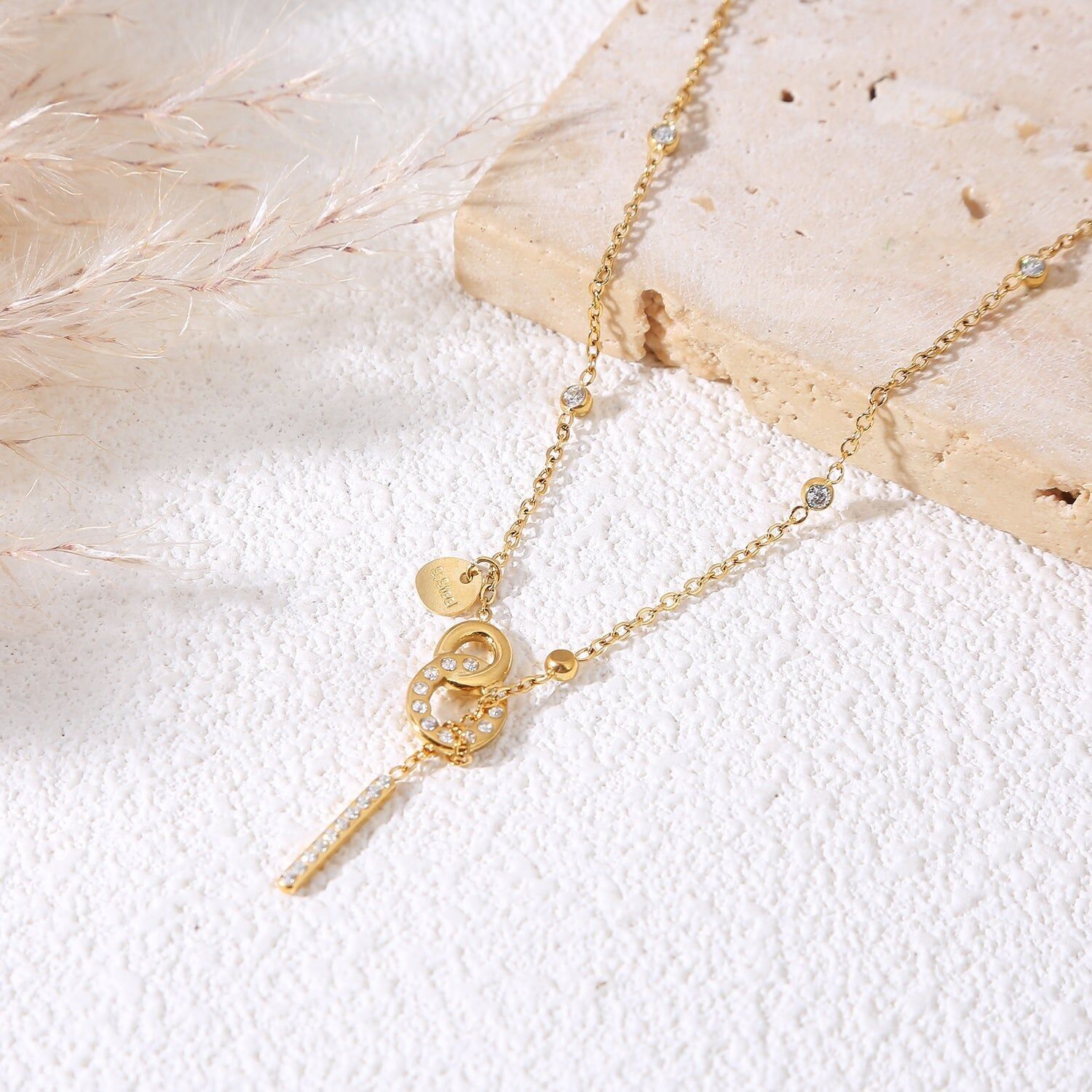 Collana in oro con una catena sottile incastonata di strass e una chiusura a barretta con una barra verticale di strass