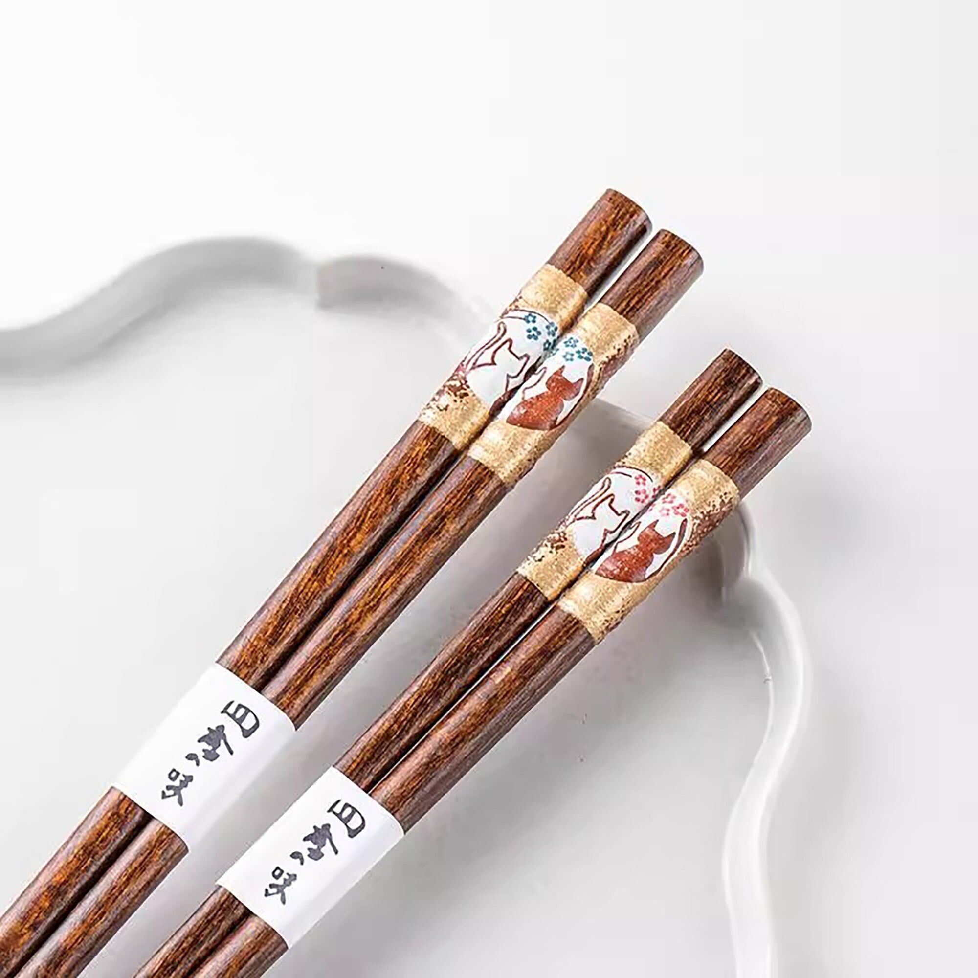 Bacchette di legno con gatti sotto i fiori di ciliegio