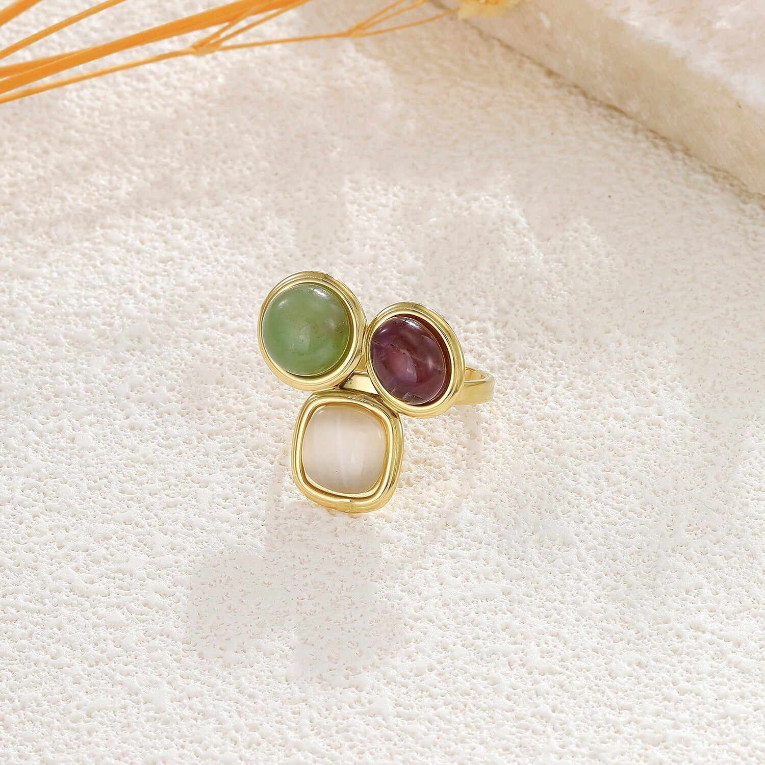 Anello regolabile in oro con tre pietre colorate e forme arrotondate