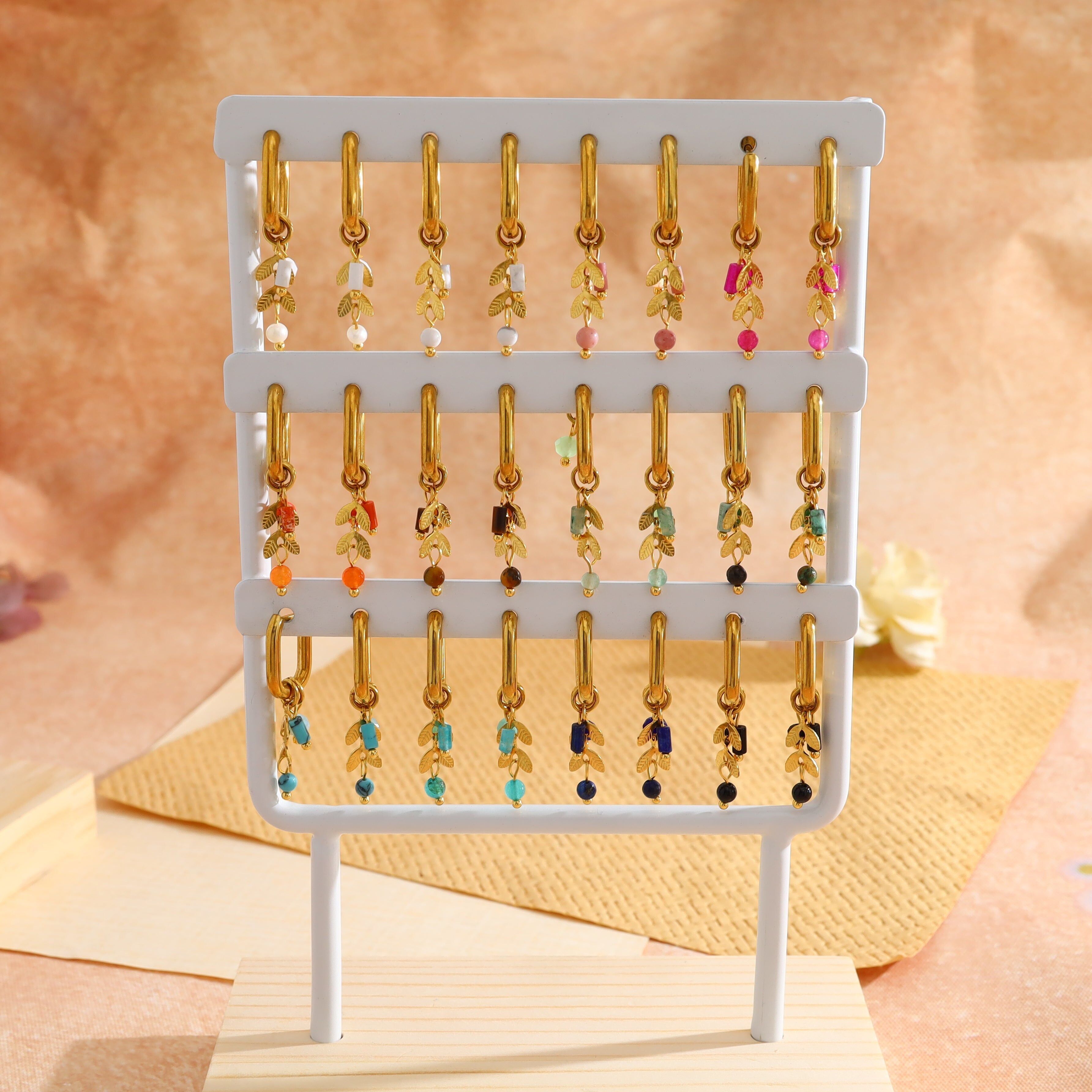 Set mit 12 Paar vergoldeten Mini-Creolen mit Blattmotiven und Natursteinen