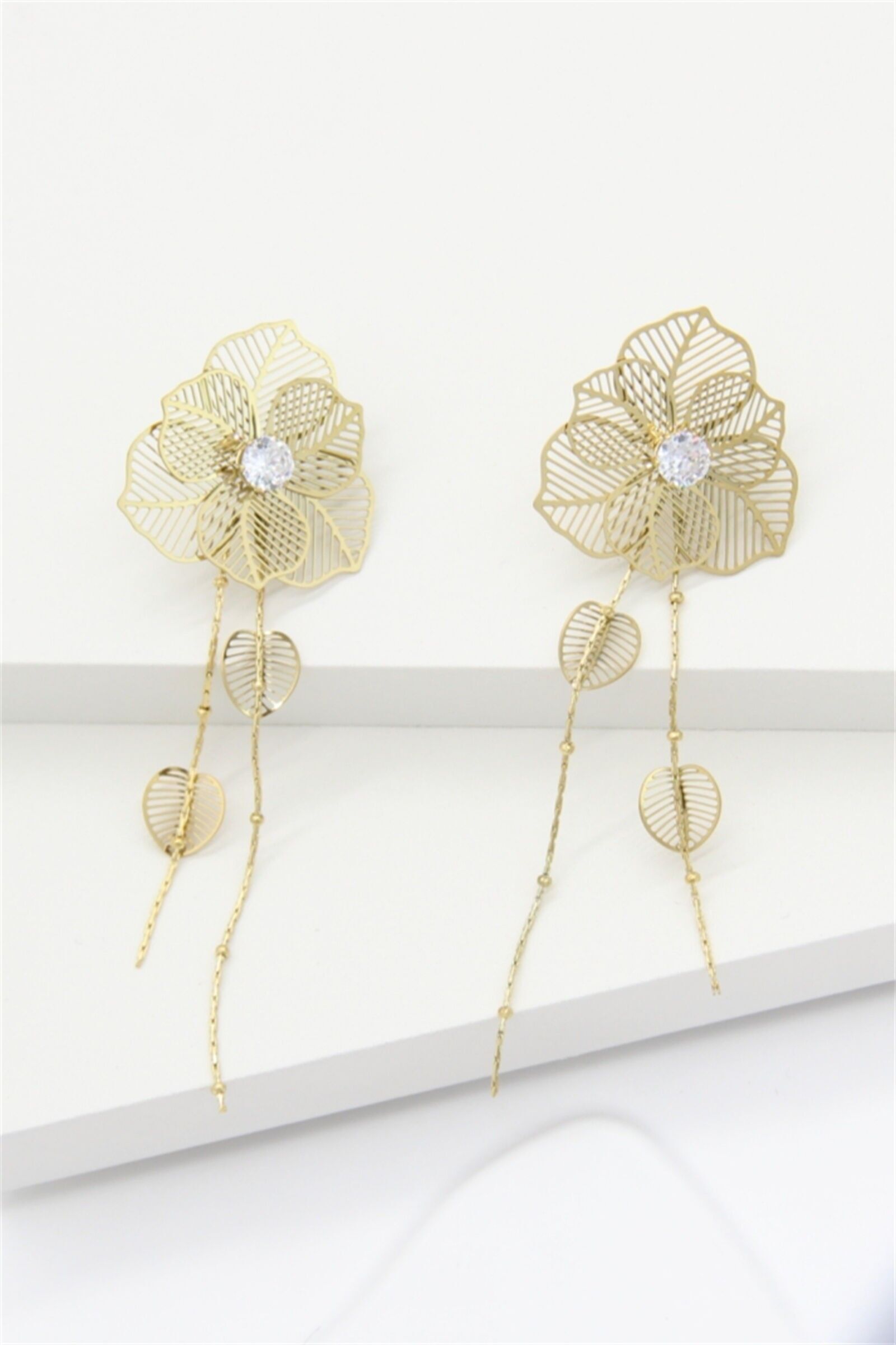 Goldene Ohrringe mit Blume und baumelndem Blatt – Eleganz und Leichtigkeit