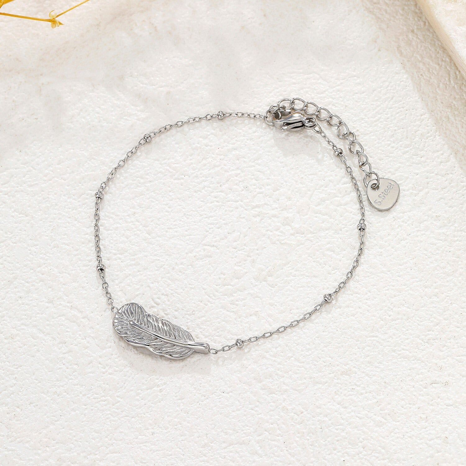 Bracciale in argento con catena sottile e pendente a forma di piuma testurizzata