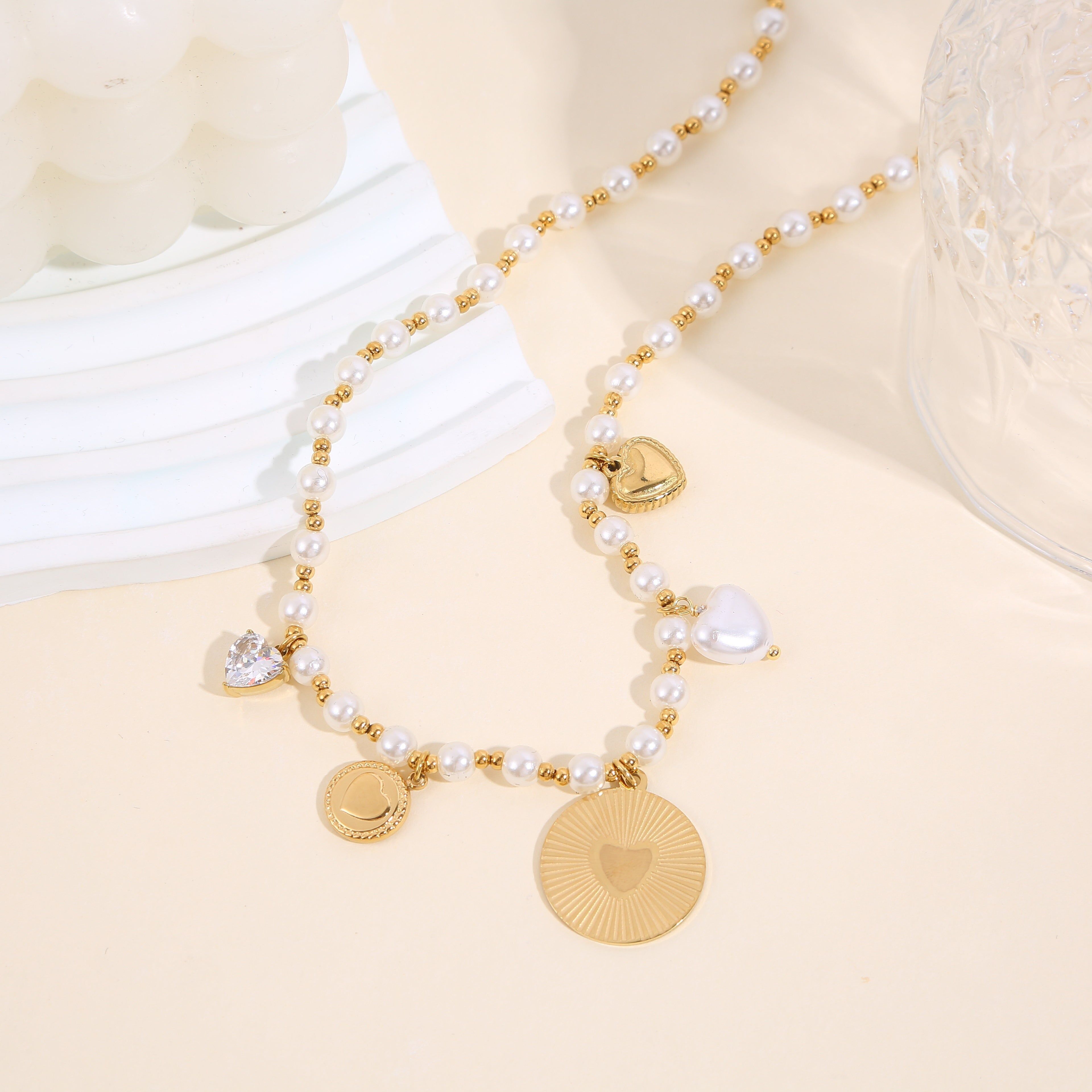 Collana a catena in oro con ciondoli a sfera e perle bianche e cuori
