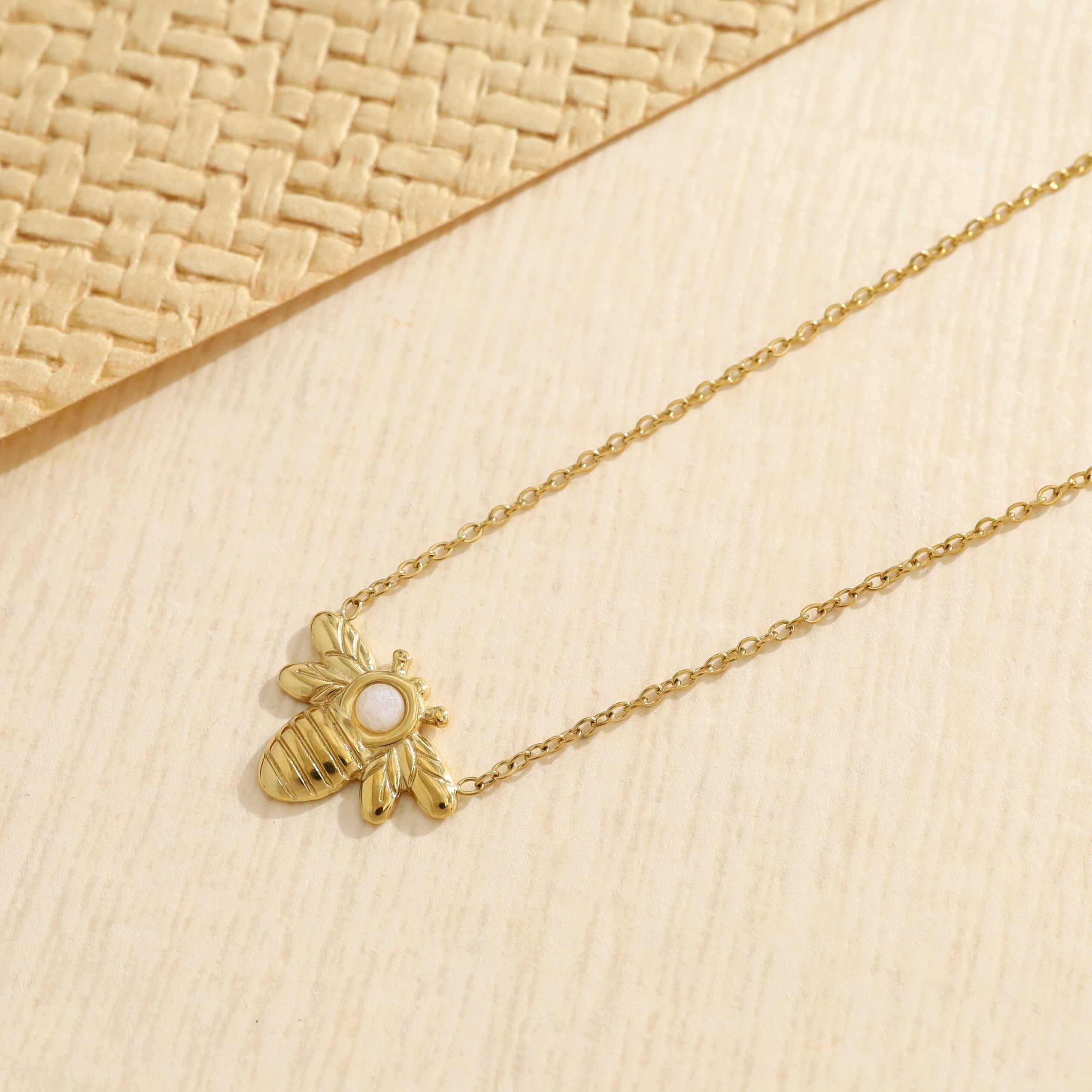 Collana in oro con catena sottile e ciondolo a forma di ape in pietra bianca