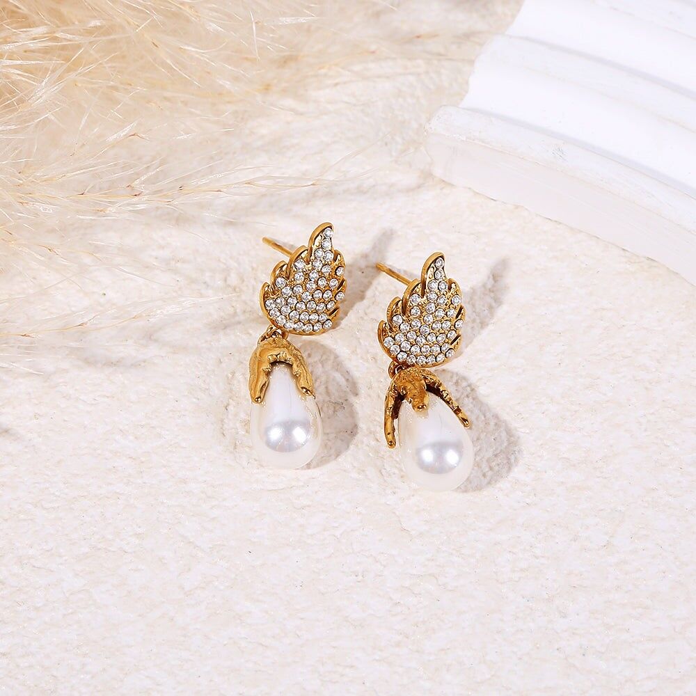 Orecchini pendenti a forma di fiamma color oro con strass e perla