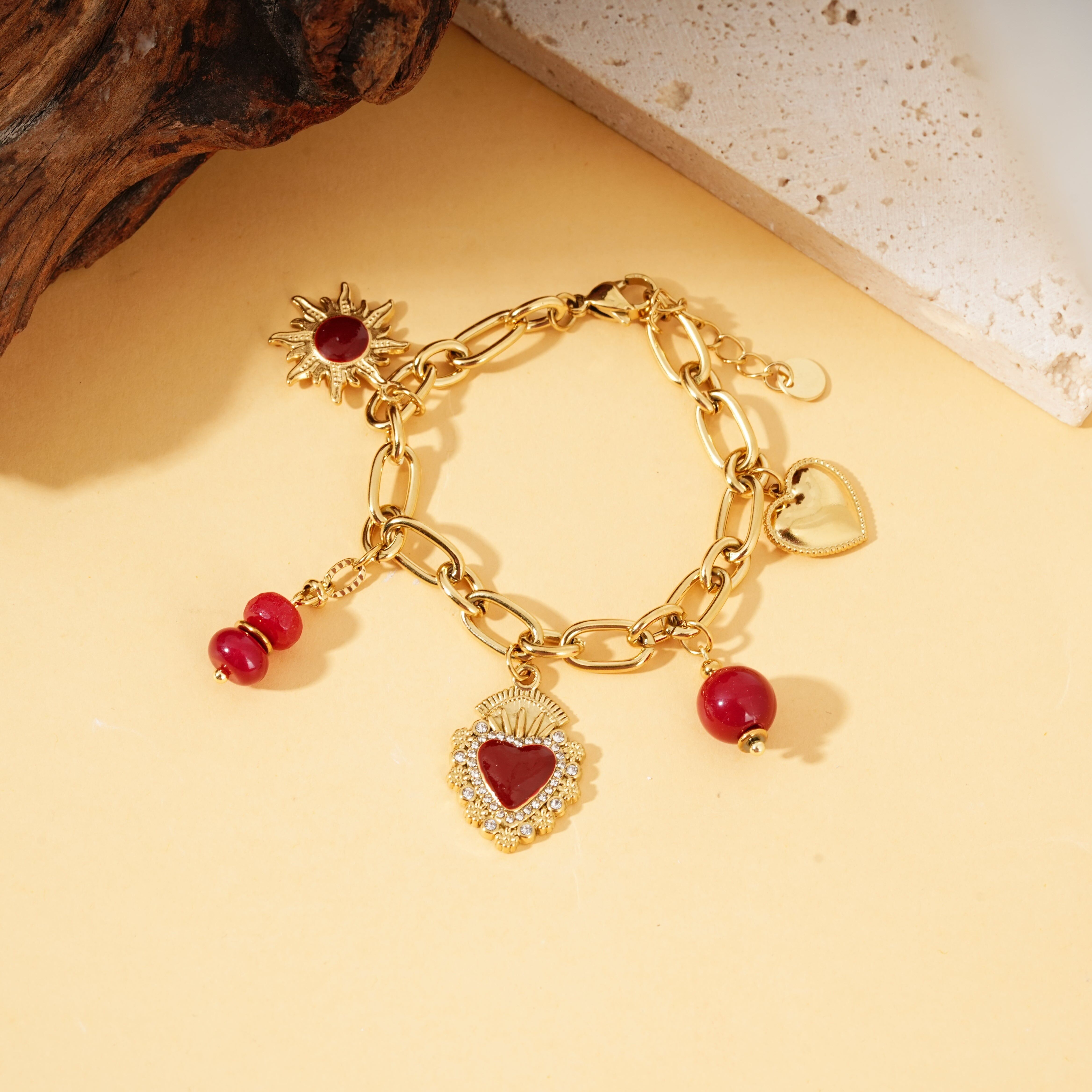 Bracciale in oro con ciondoli a forma di cuore, perline ex voto e perline rosse