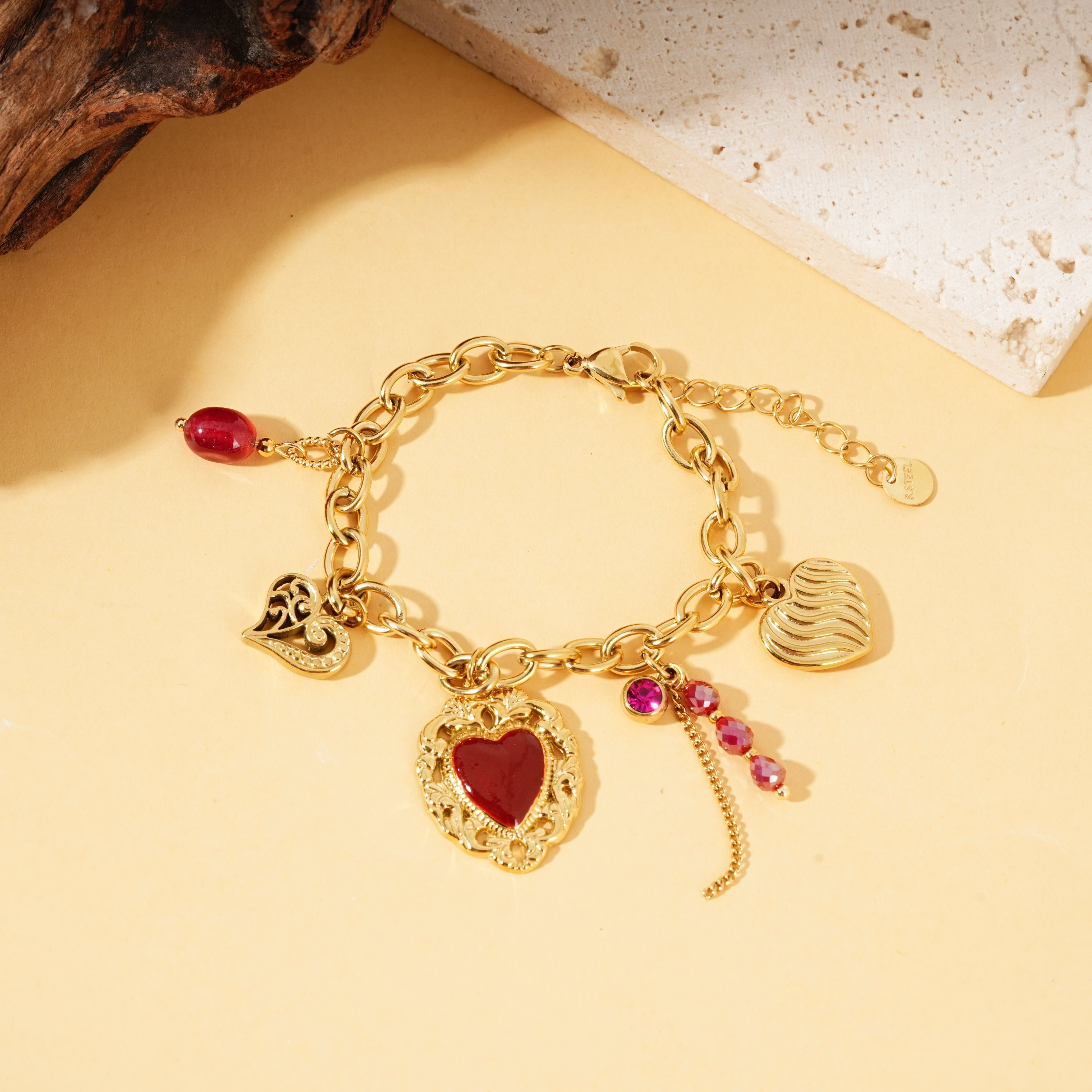 Bracciale in oro con pendenti a forma di cuore e pietre ex voto, pietre rosse
