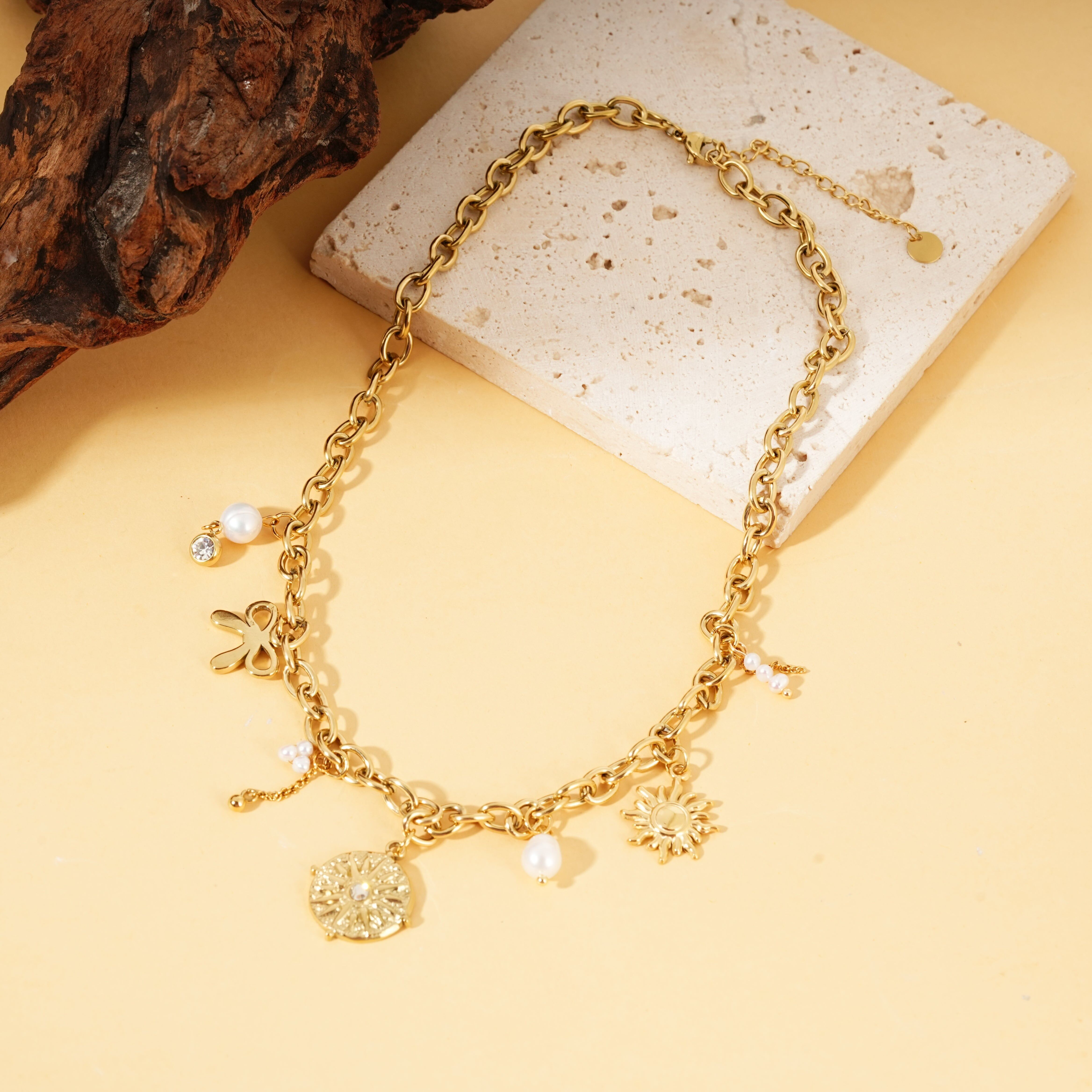 Collana con catena in oro con ciondoli a forma di bussola in strass e perle bianche