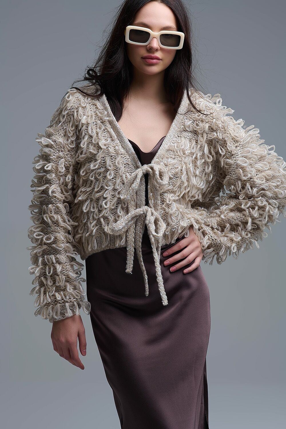 Cardigan beige corto in maglia grossa con scollo a V e chiusura anteriore con lacci