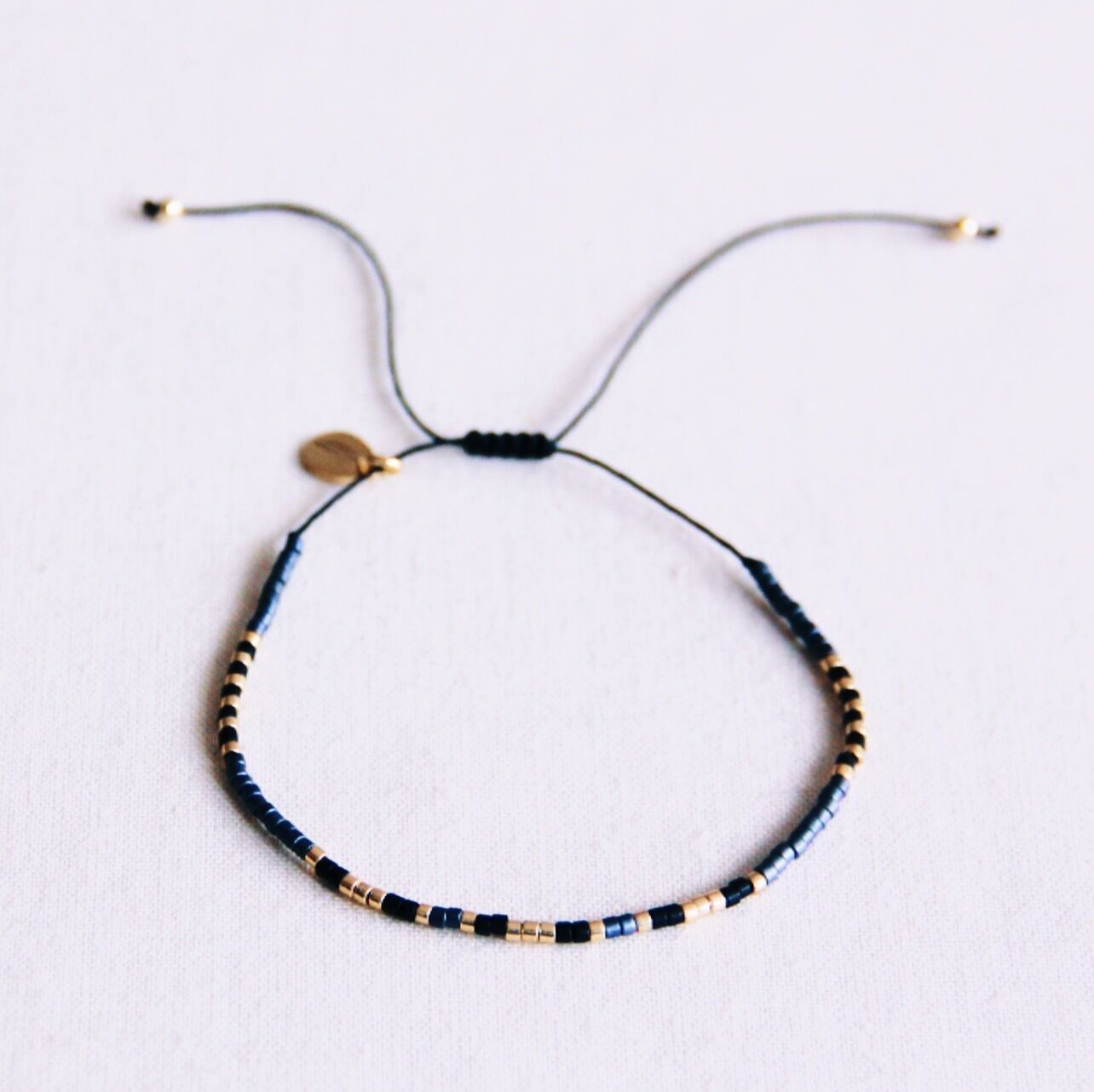 Pulsera Miyuki - negra/gris/chapada en oro