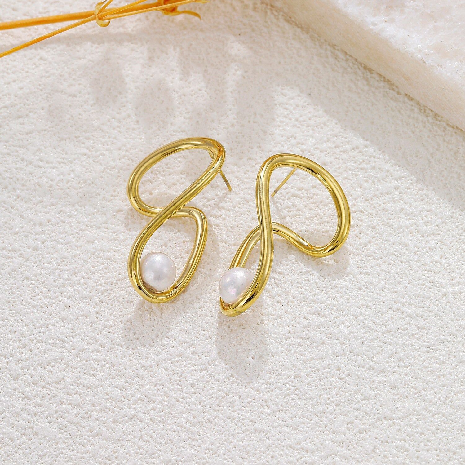 Orecchini asimmetrici in oro con perla