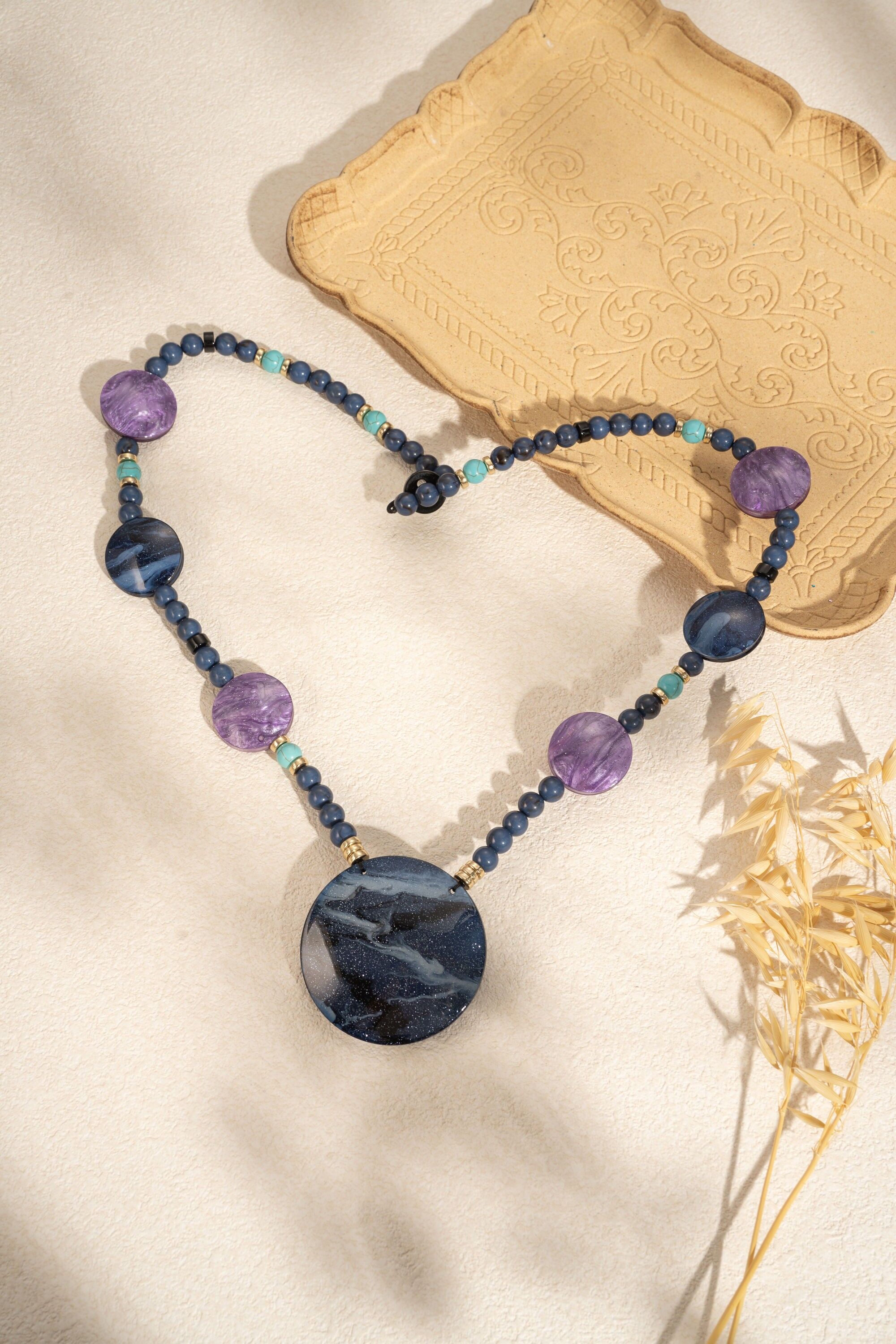 Lange Harzkette mit rundem, marmoriertem Anhänger