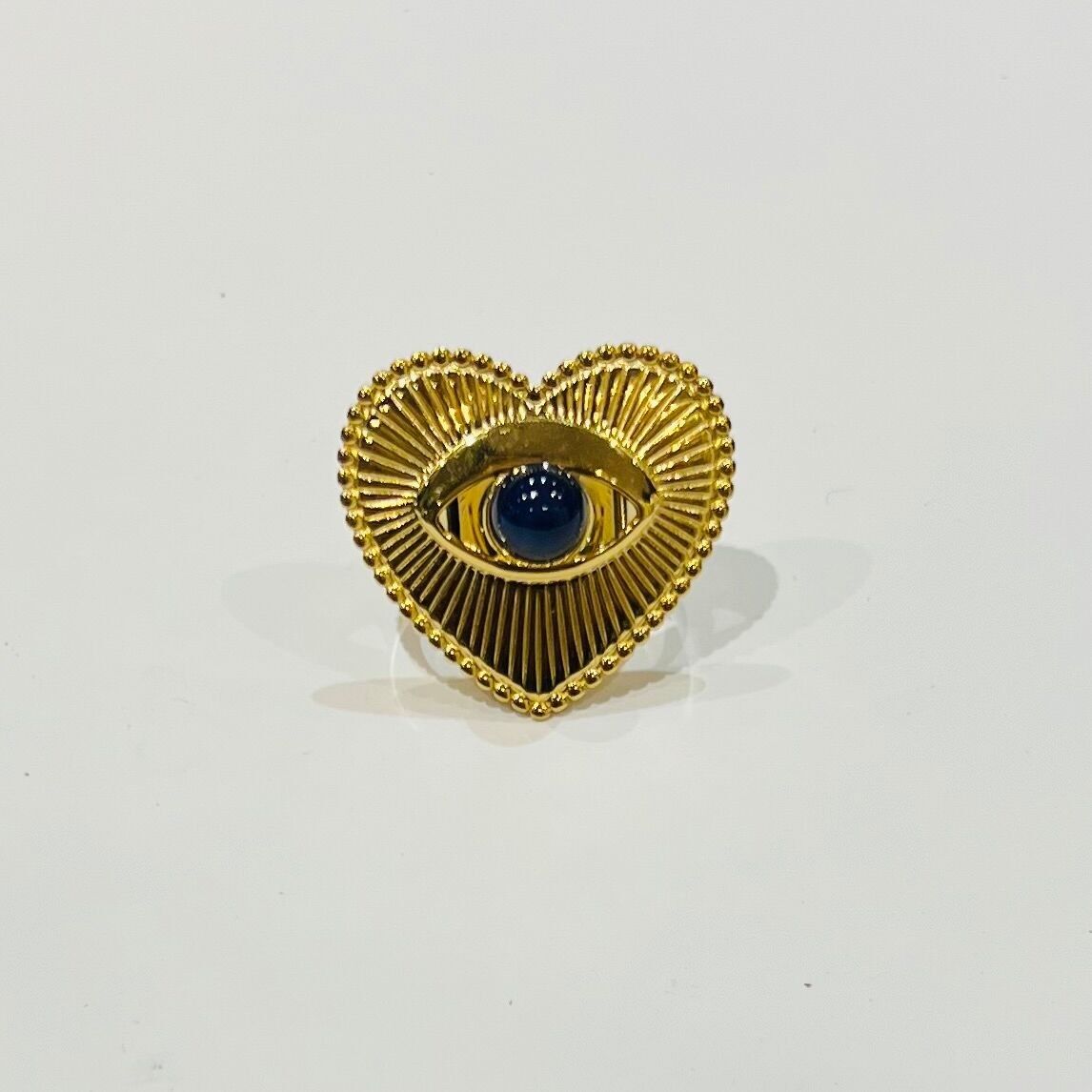 Anello in acciaio inossidabile con cuore placcato oro, occhio centrale e pietra incastonata.