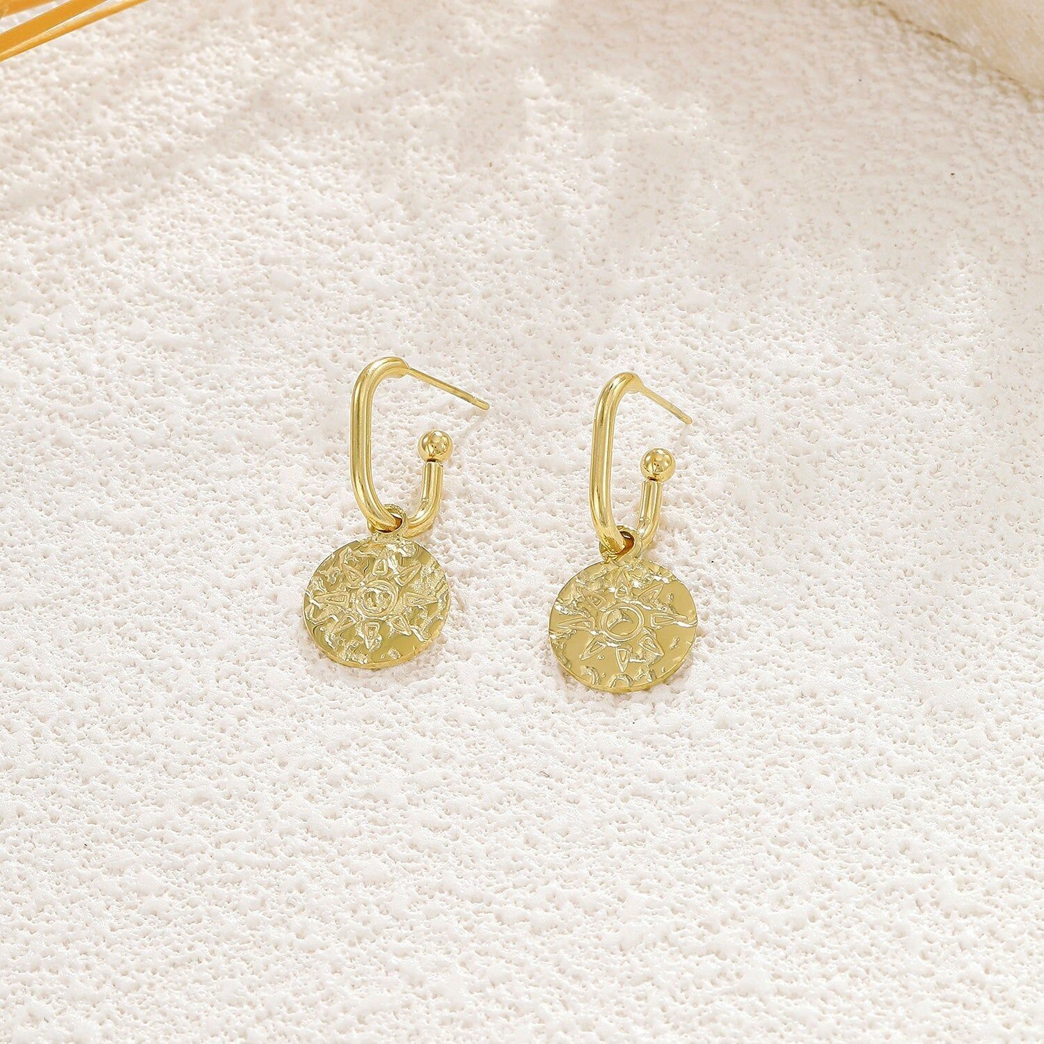 Orecchini a cerchio aperti in oro con pendente a forma di sole martellato