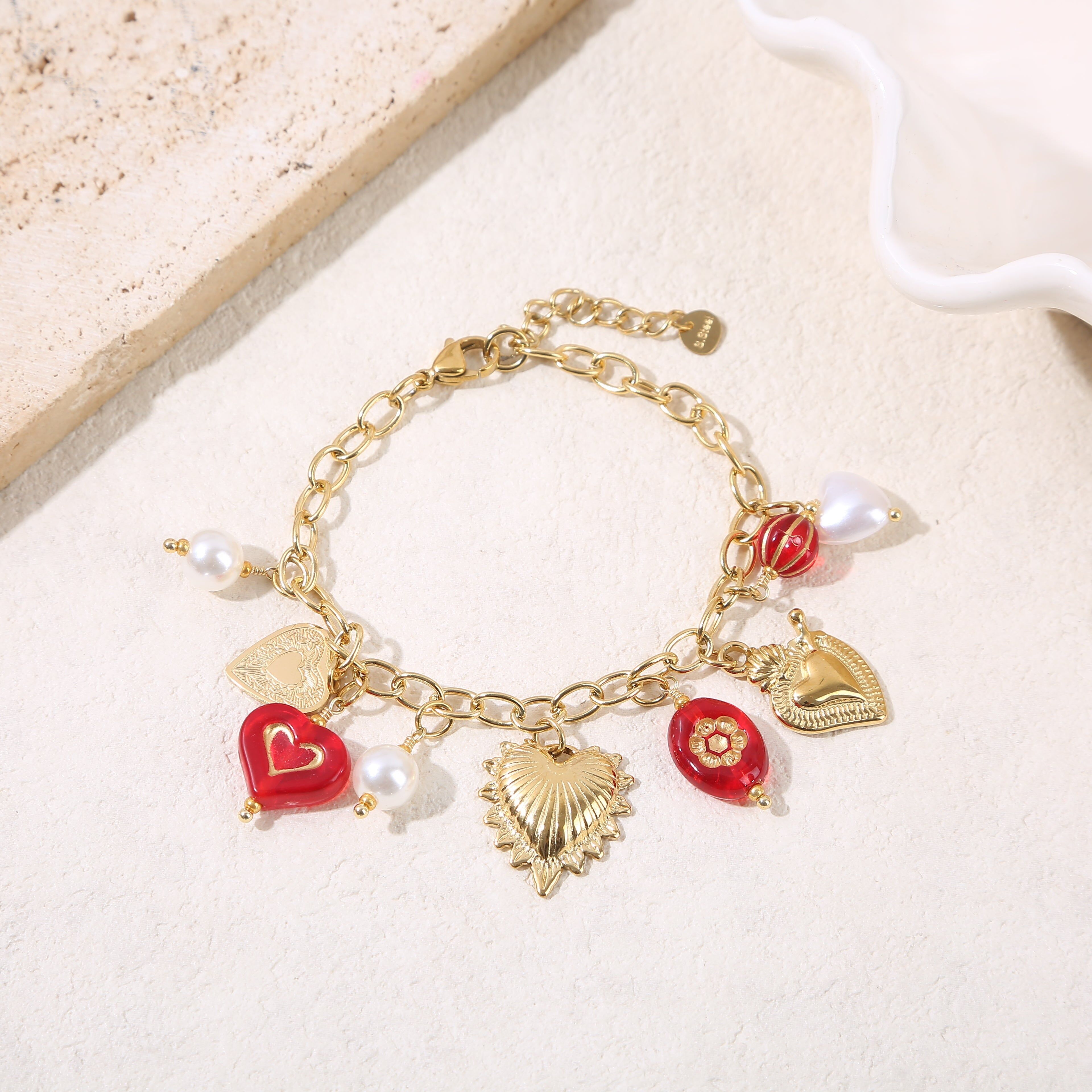 Bracciale a catena in oro con ciondoli a forma di cuore e resina rossa