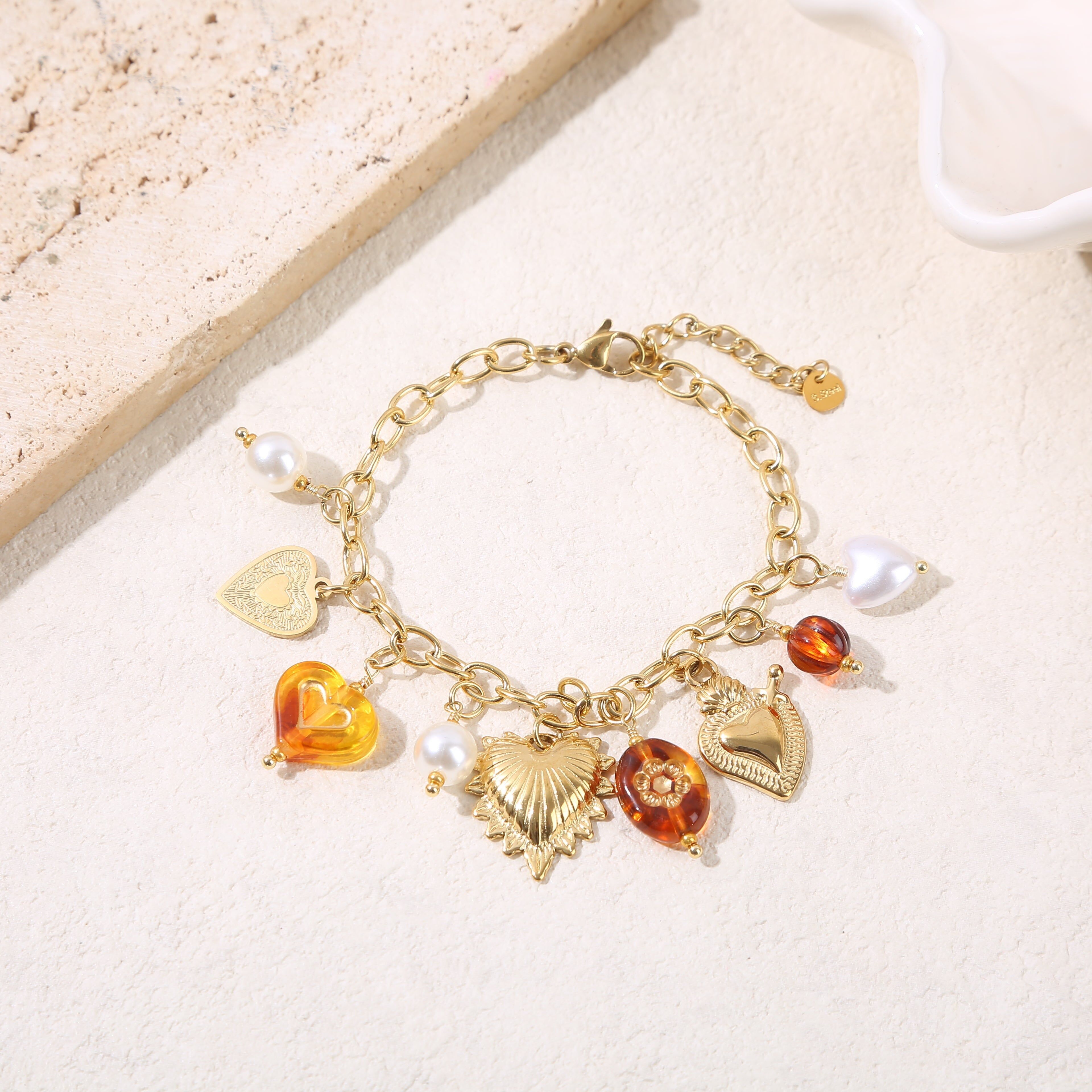 Bracciale a catena in oro con ciondoli a forma di cuore e resina ambrata