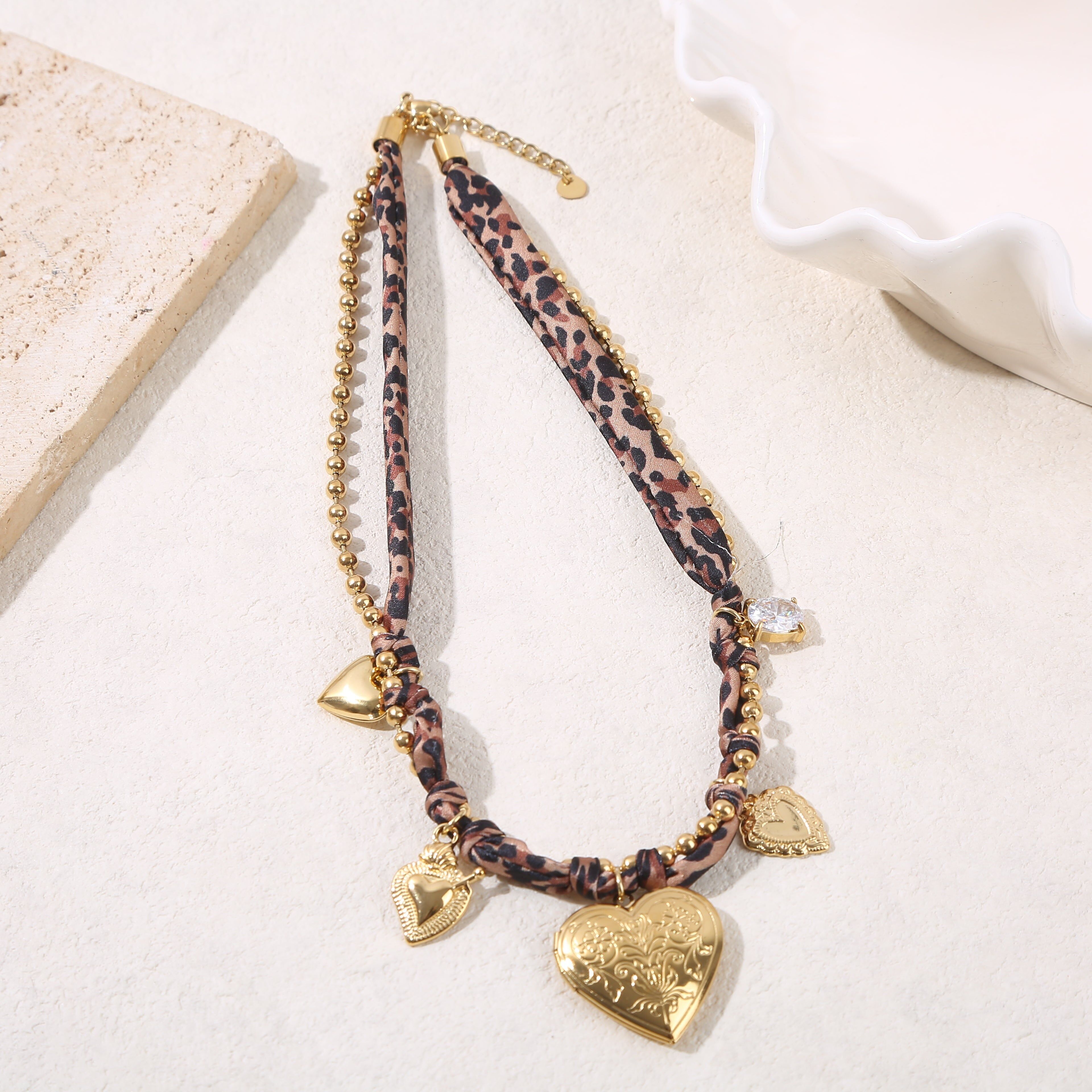 Collana di perline dorate con tessuto leopardato e grandi ciondoli a forma di cuore