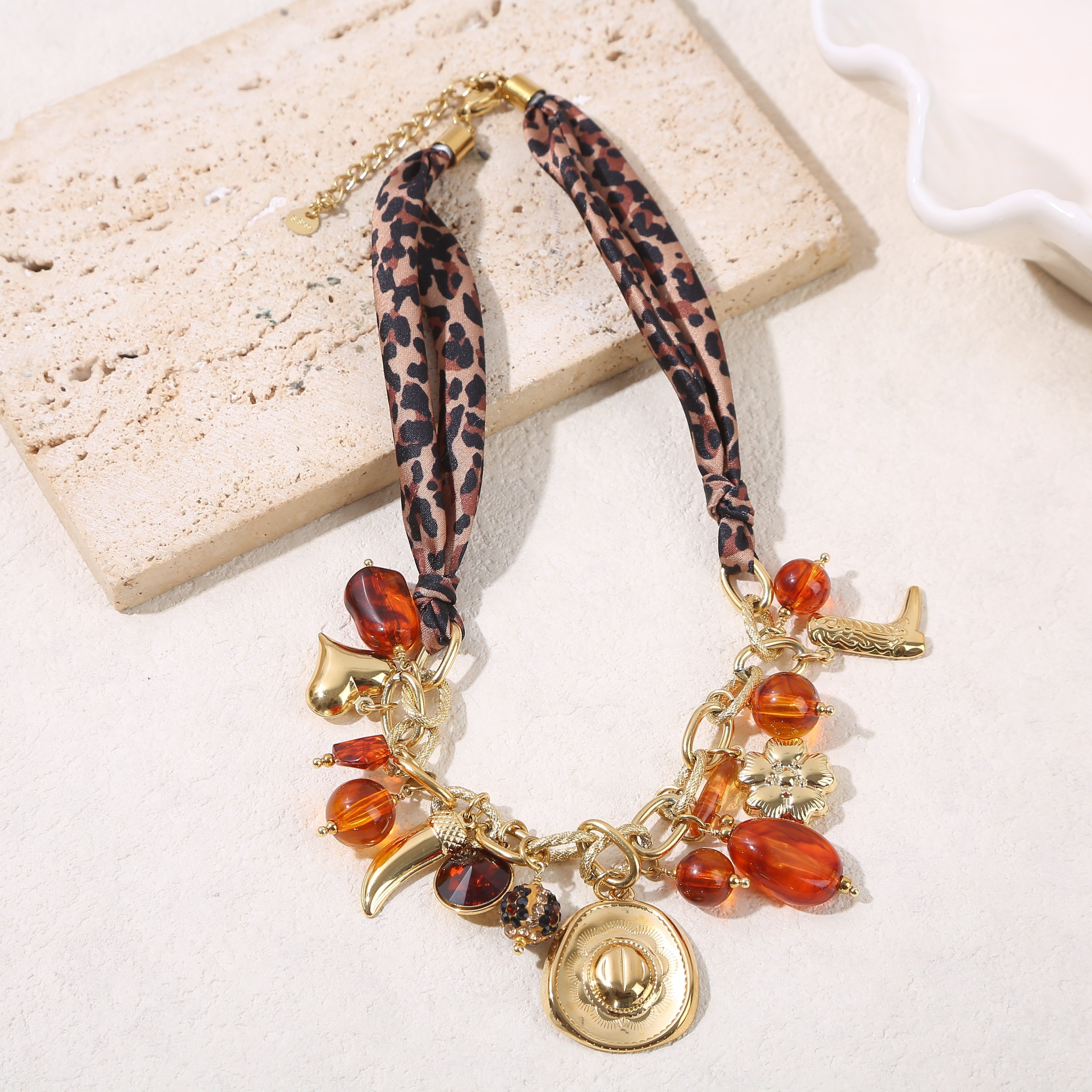 Collana con catena testurizzata in oro con tessuto leopardato, ciondoli da cowboy e resina ambrata