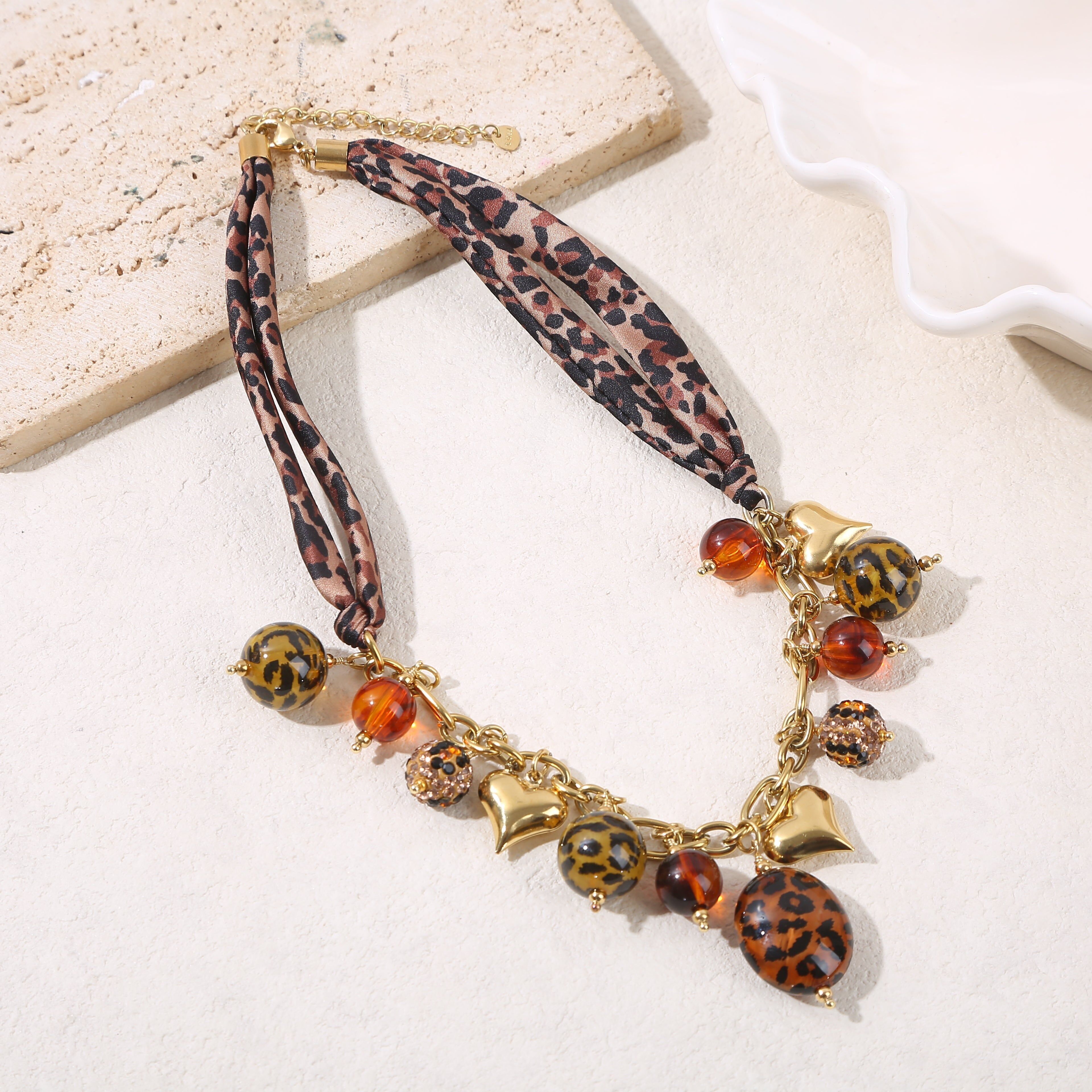 Collana con catena in oro con pendenti in tessuto con stampa leopardata e resina con stampa leopardata