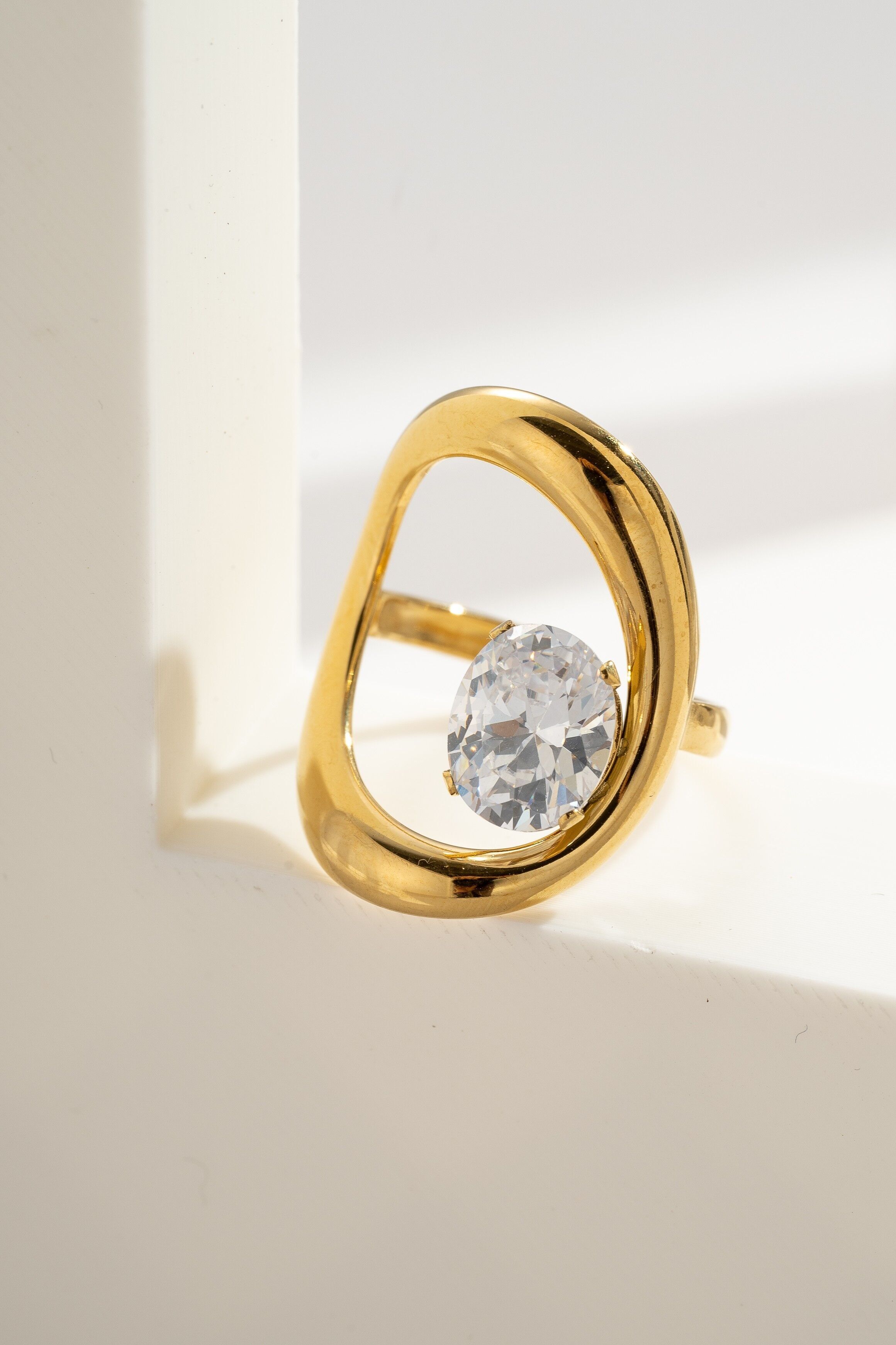 Funkelnder Goldkristallring mit asymmetrischem Edelstahlrahmen