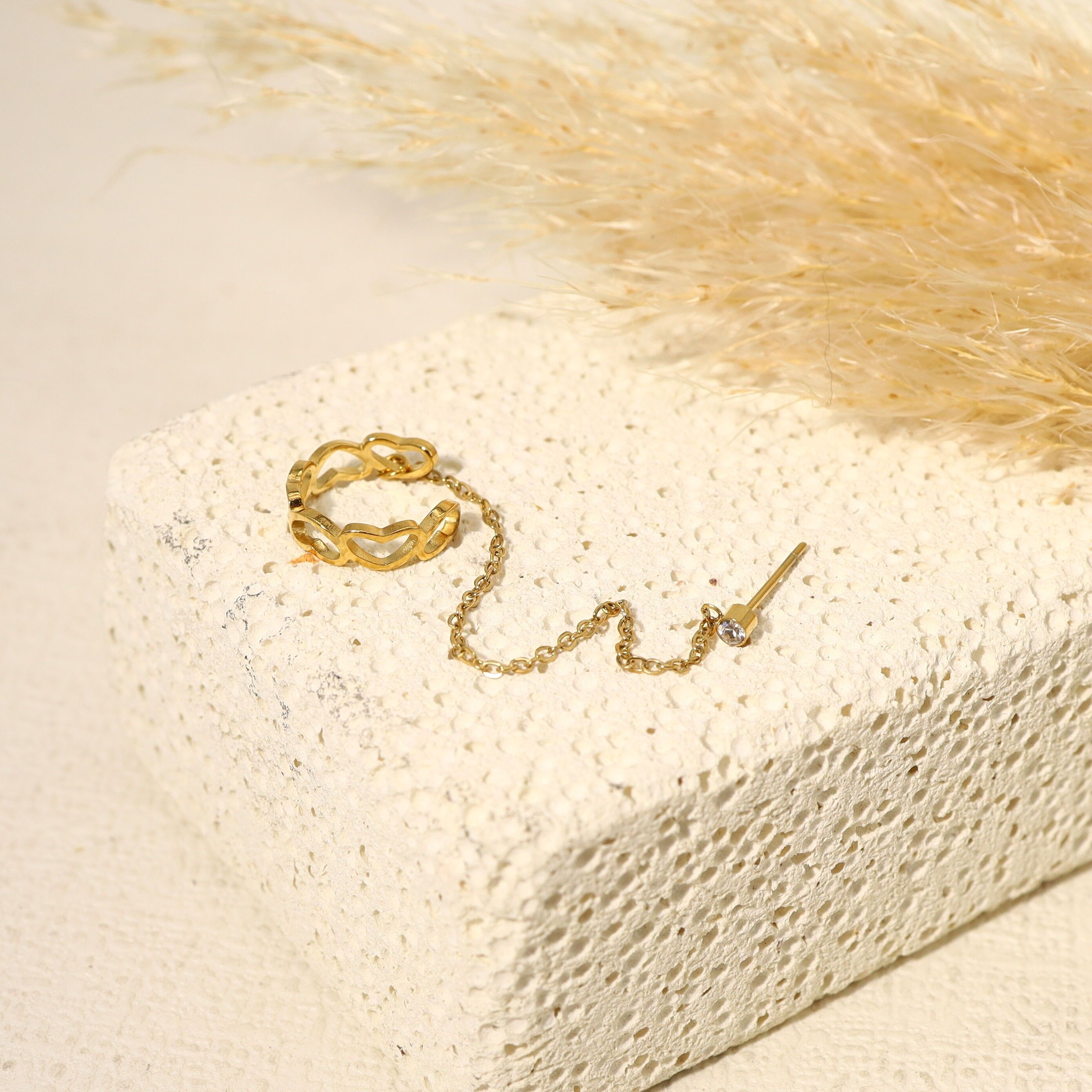 Orecchino ear cuff collegato da una catena a un singolo anello di strass