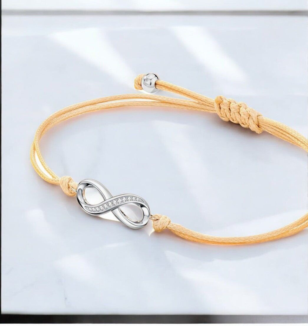 Bracciale "INFINITO", cordino beige regolabile, simbolo infinito argentato