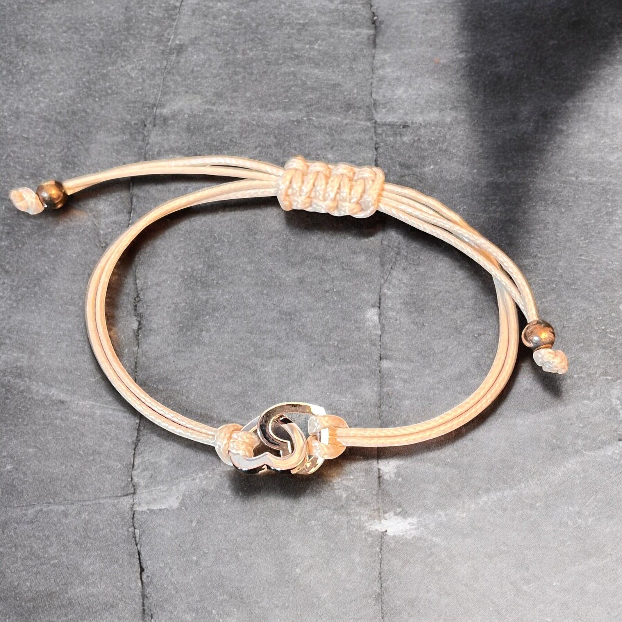 Bracciale "CORAZON", cordino beige regolabile, due cuori argentati