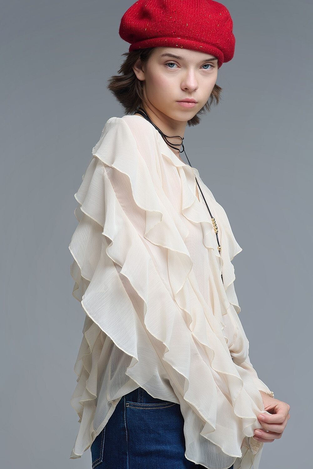 Blusa beige con scollo a V e volant su tutta la superficie